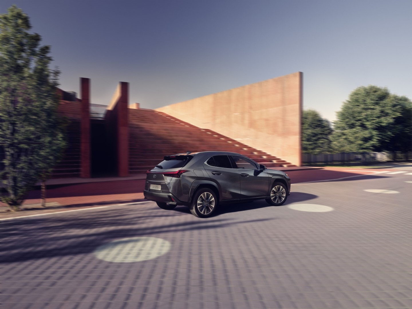 Perfil del Lexus UX300e con un juego de luces y sombras en un contexto urbano.