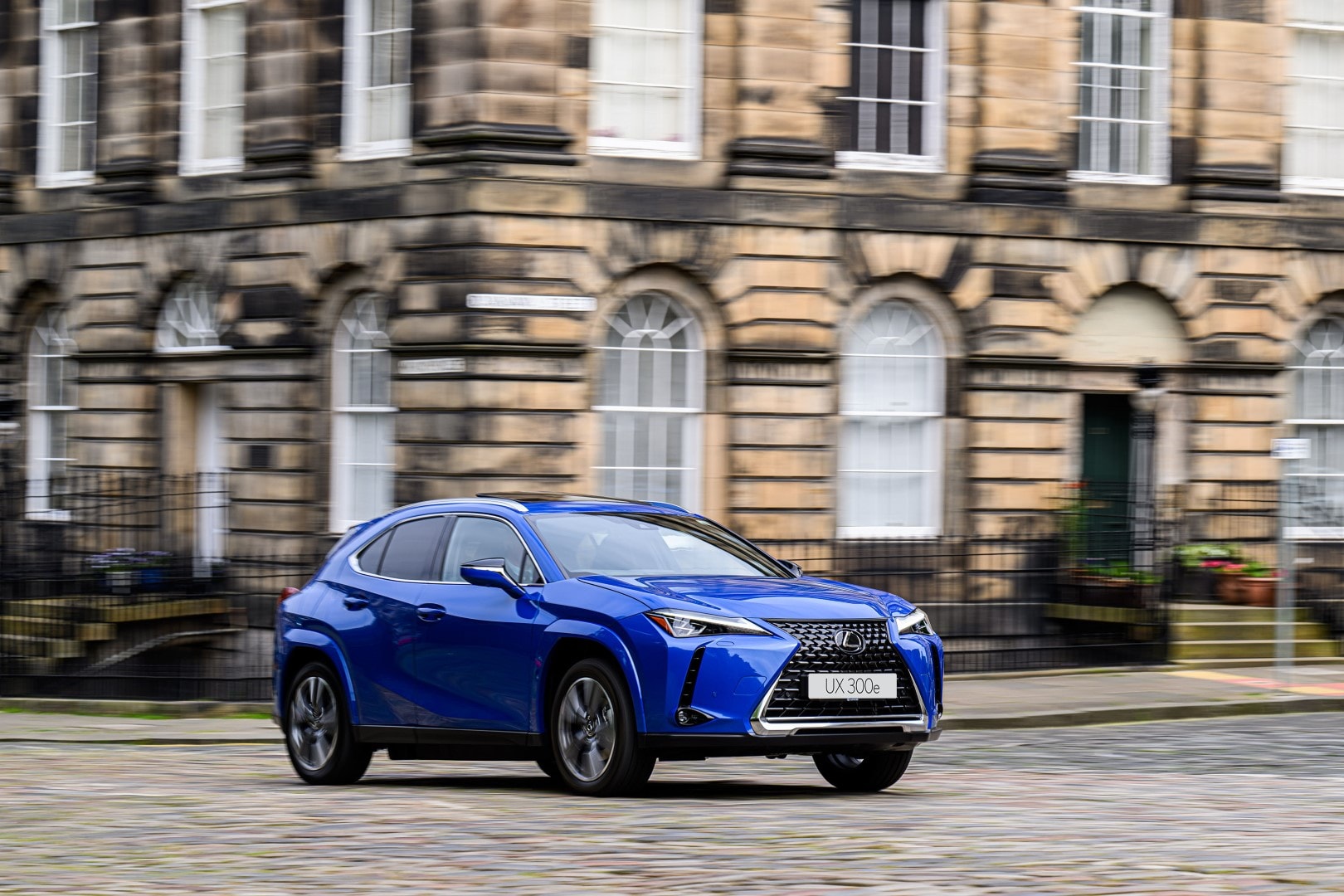 Vista dinámica del Lexus UX300e en movimiento por calles de ciudad.