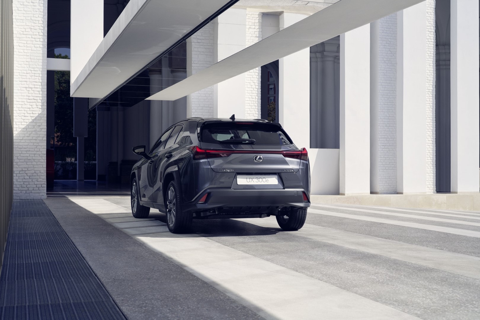Vista trasera y lateral del Lexus UX300e en entorno urbano.