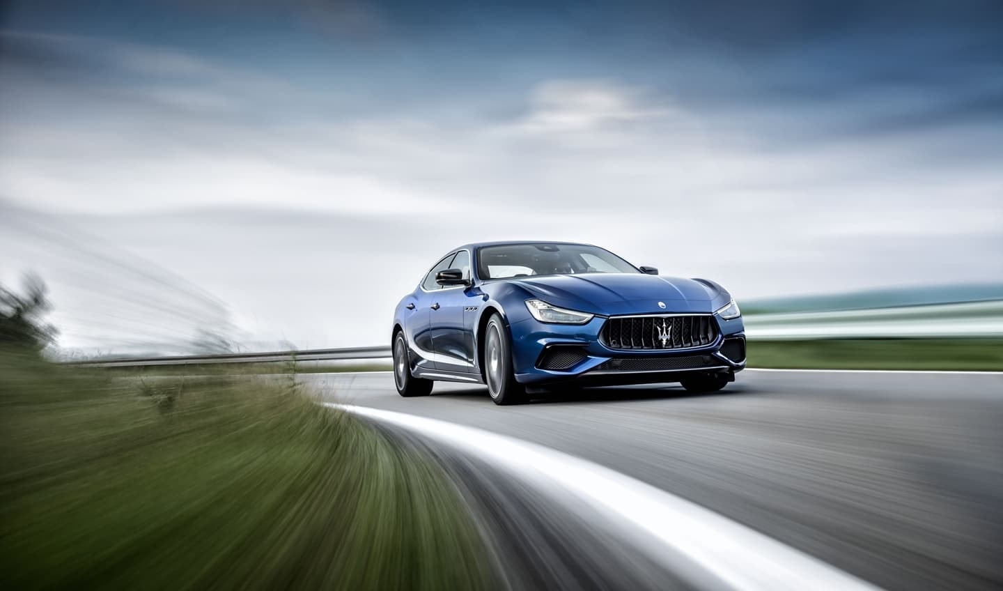 El Maserati Ghibli en pleno dinamismo, mostrando su frontal y lateral con un fondo borroso.