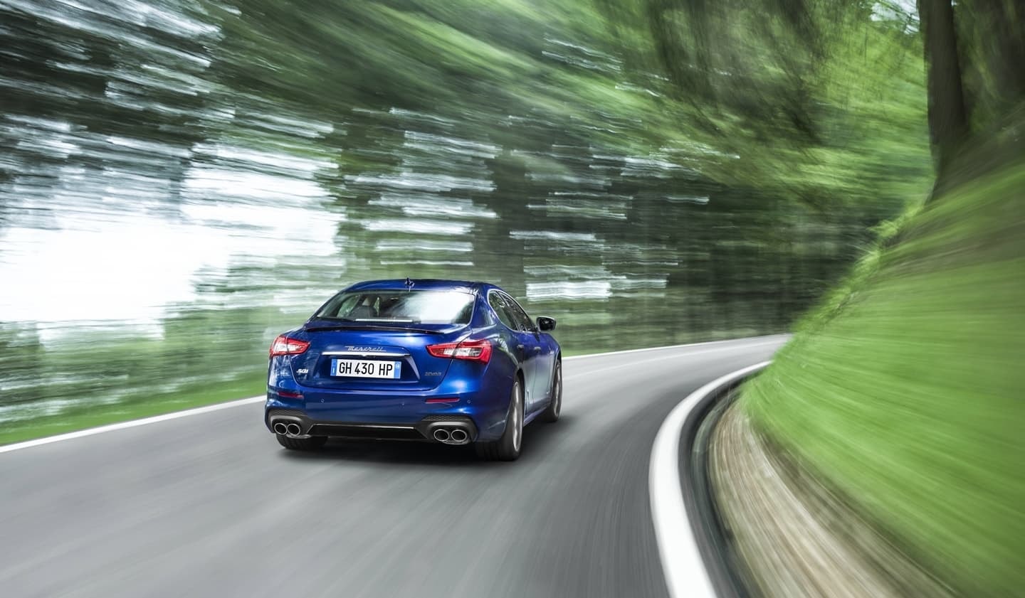 Trasera del Ghibli capturada con una técnica de barrido para enfatizar su velocidad en carretera.