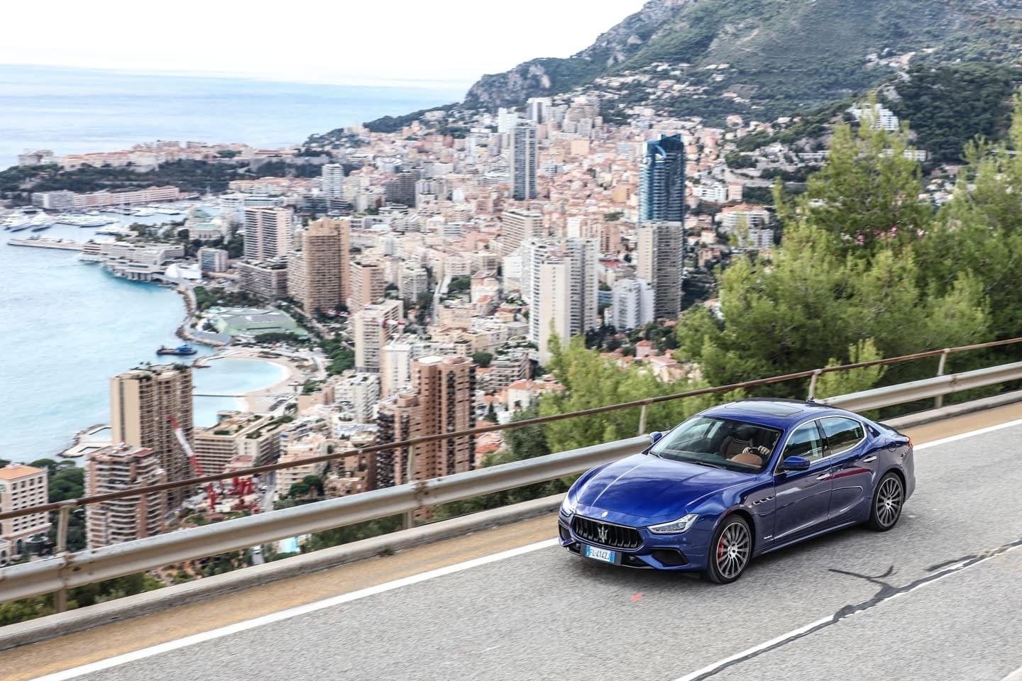El Maserati Ghibli adelanta con estilo frente a la panorámica urbana.