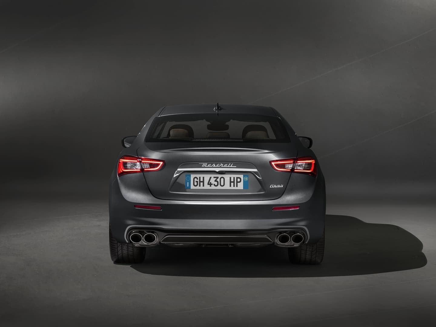 Vista trasera del Maserati Ghibli, destacando sus luces y escapes.