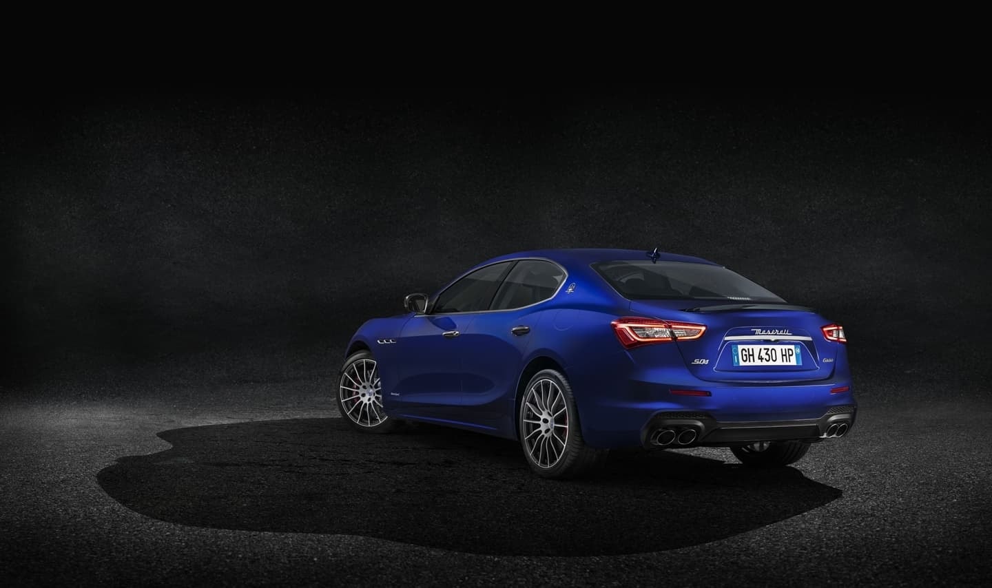 Vista trasera del Maserati Ghibli azul mostrando líneas y detalles de diseño.