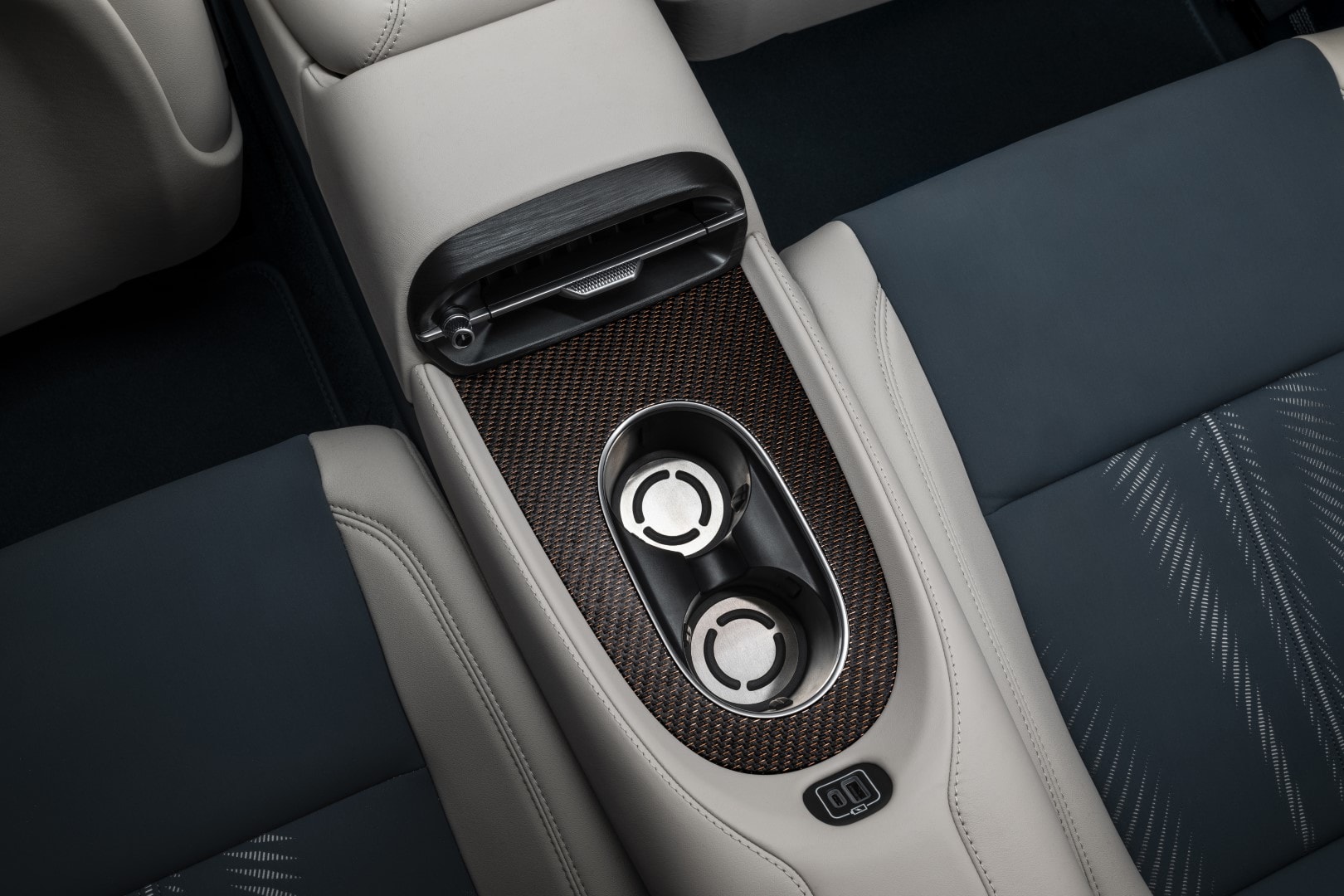 Vista de la consola central con detalles de madera y portavasos.