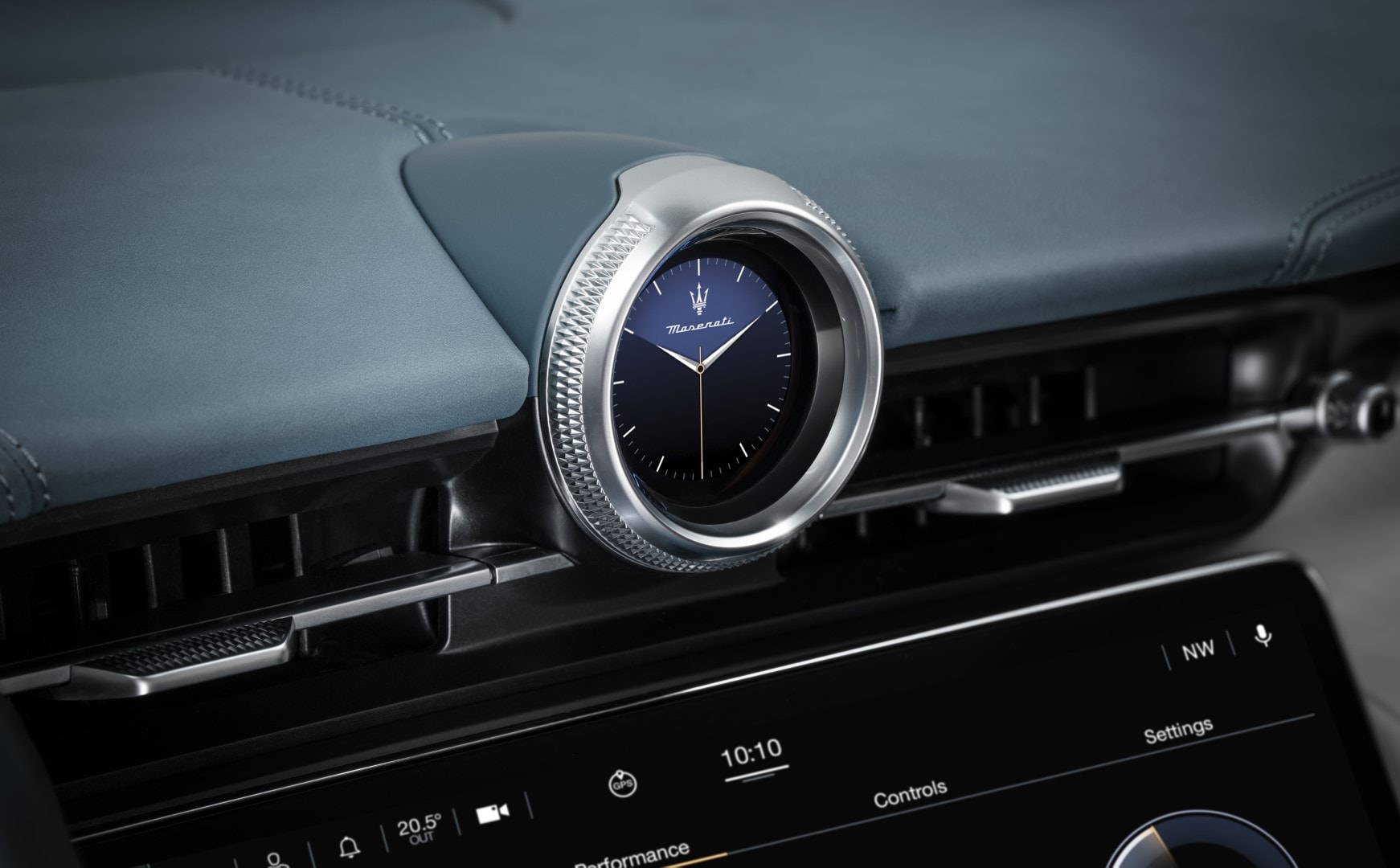 Detalle del reloj análogo sobre el tablero, distintivo de Maserati.