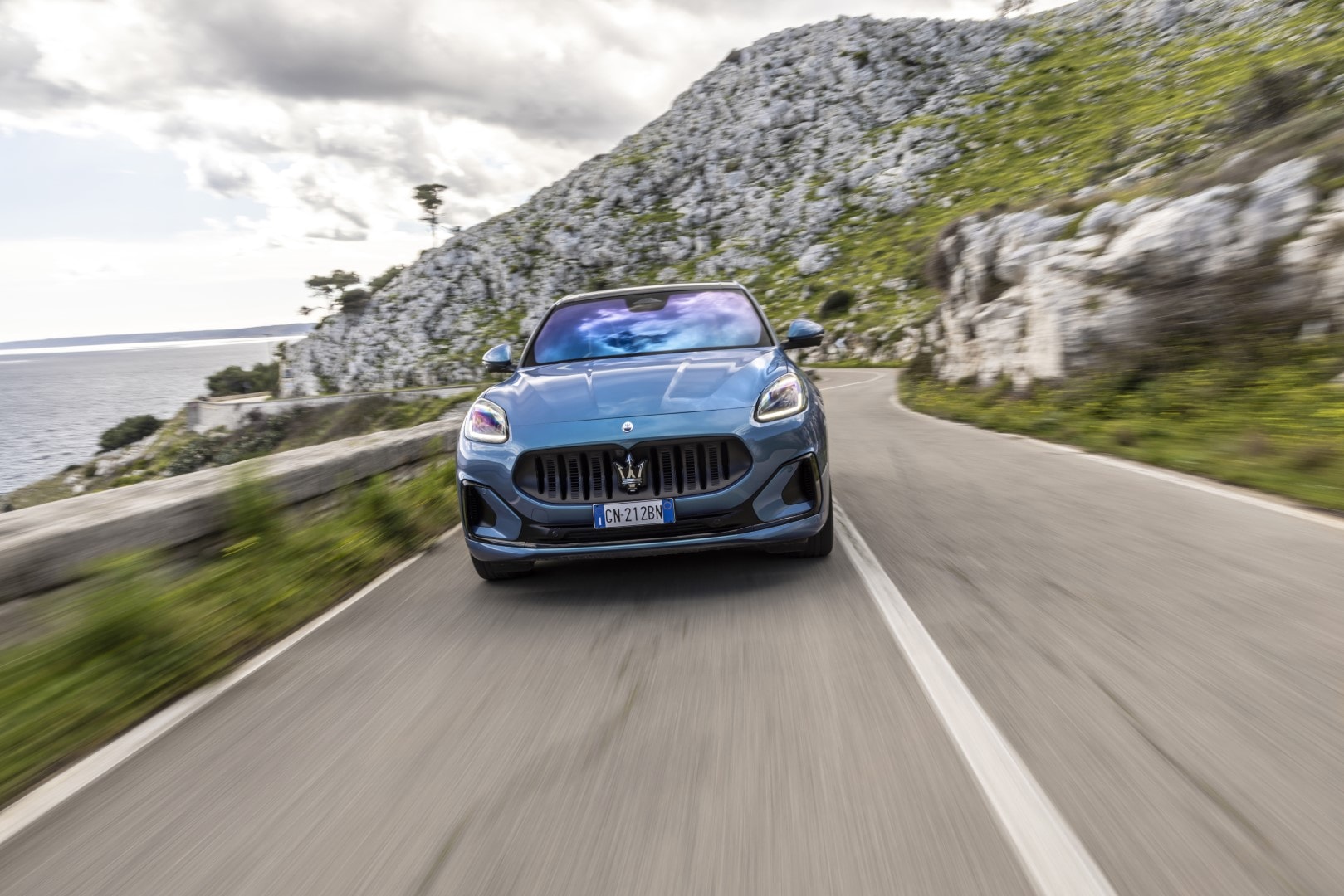 Imagen dinámica del Maserati Grecale recorriendo una carretera costera.
