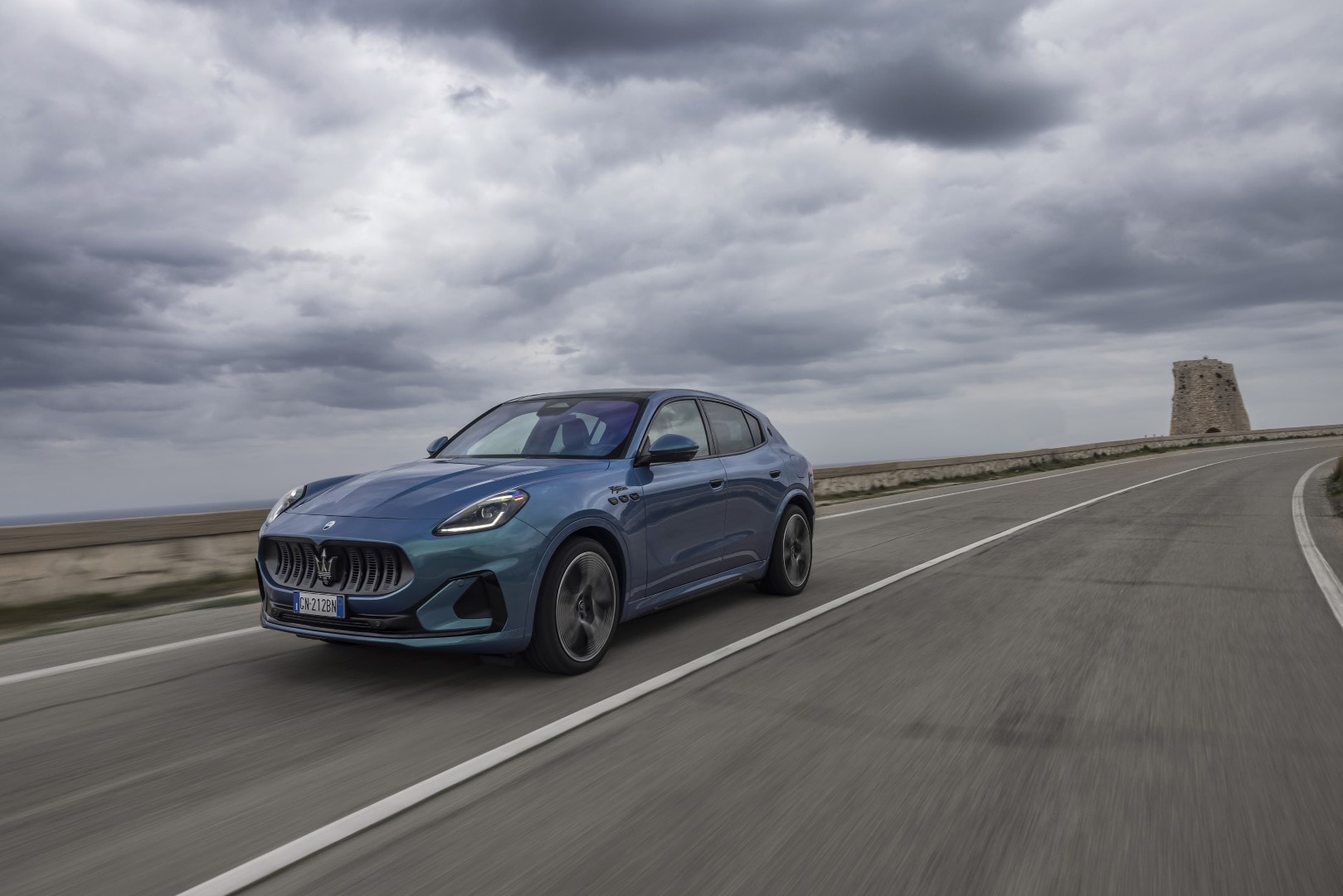 Imagen dinámica del Grecale eléctrico en la carretera, destacando su diseño frontal y lateral.