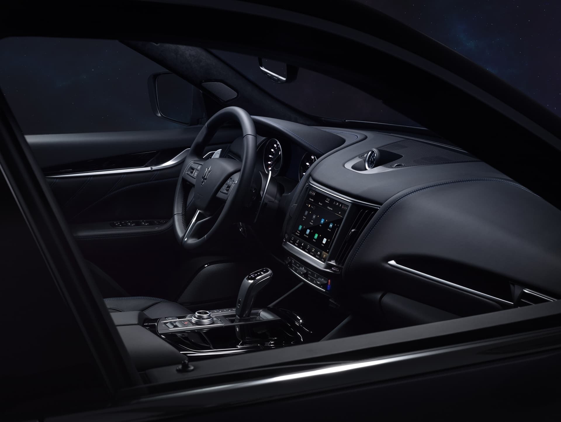 Vista de la cabina del Maserati Levante iluminada de noche, énfasis en diseño y ergonomía.