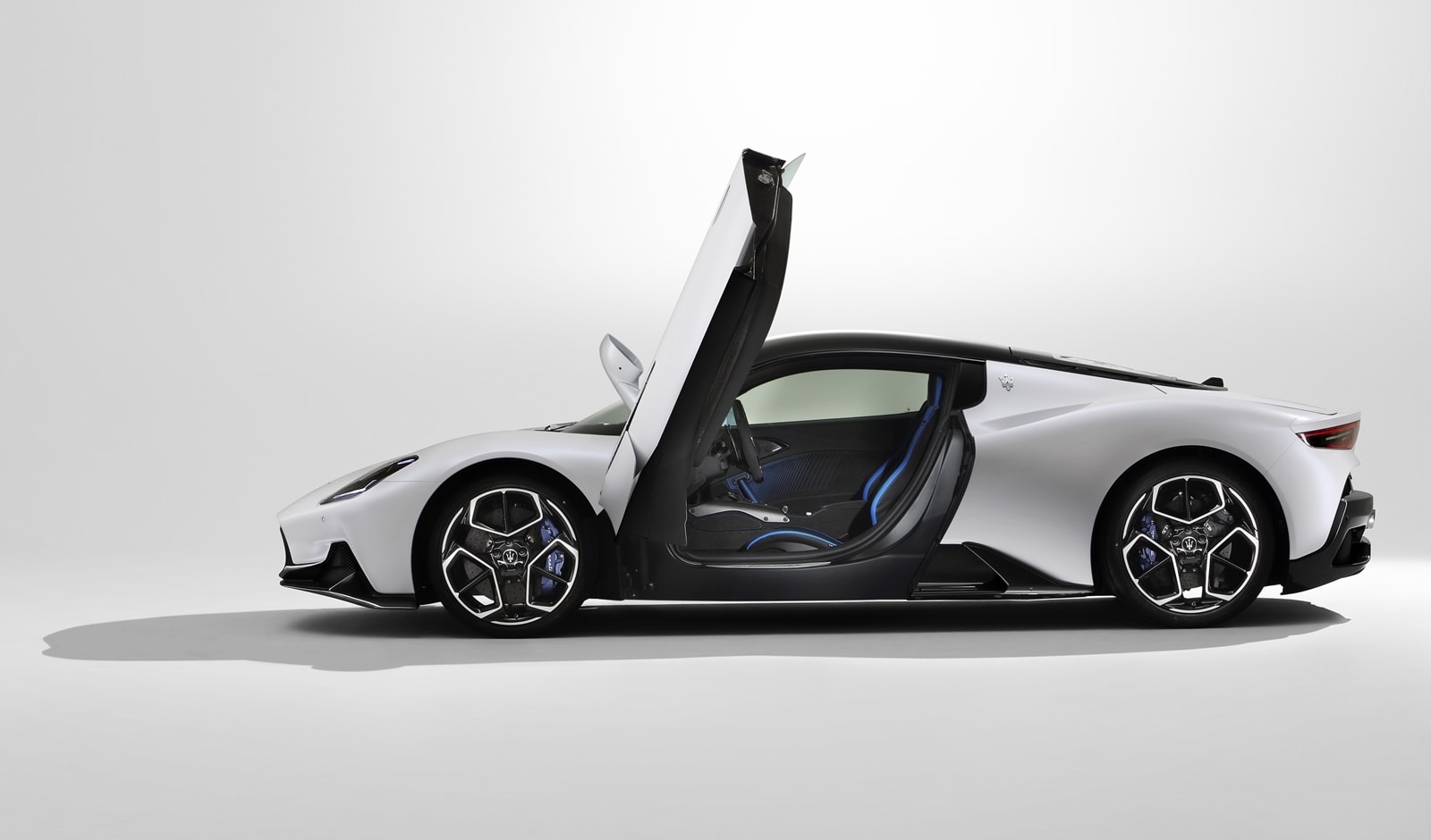 Vista lateral del Maserati MC20 con puertas de ala de gaviota abiertas.