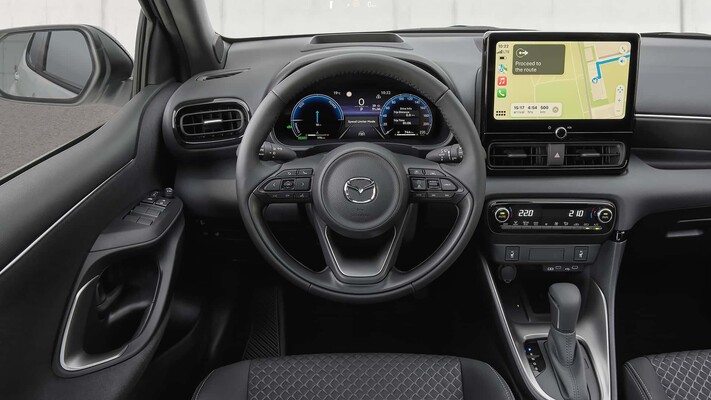 Cabina del Mazda 2 híbrido mostrando volante y disposición de asientos. Cabina del Mazda 2 híbrido mostrando volante y disposición de asientos.