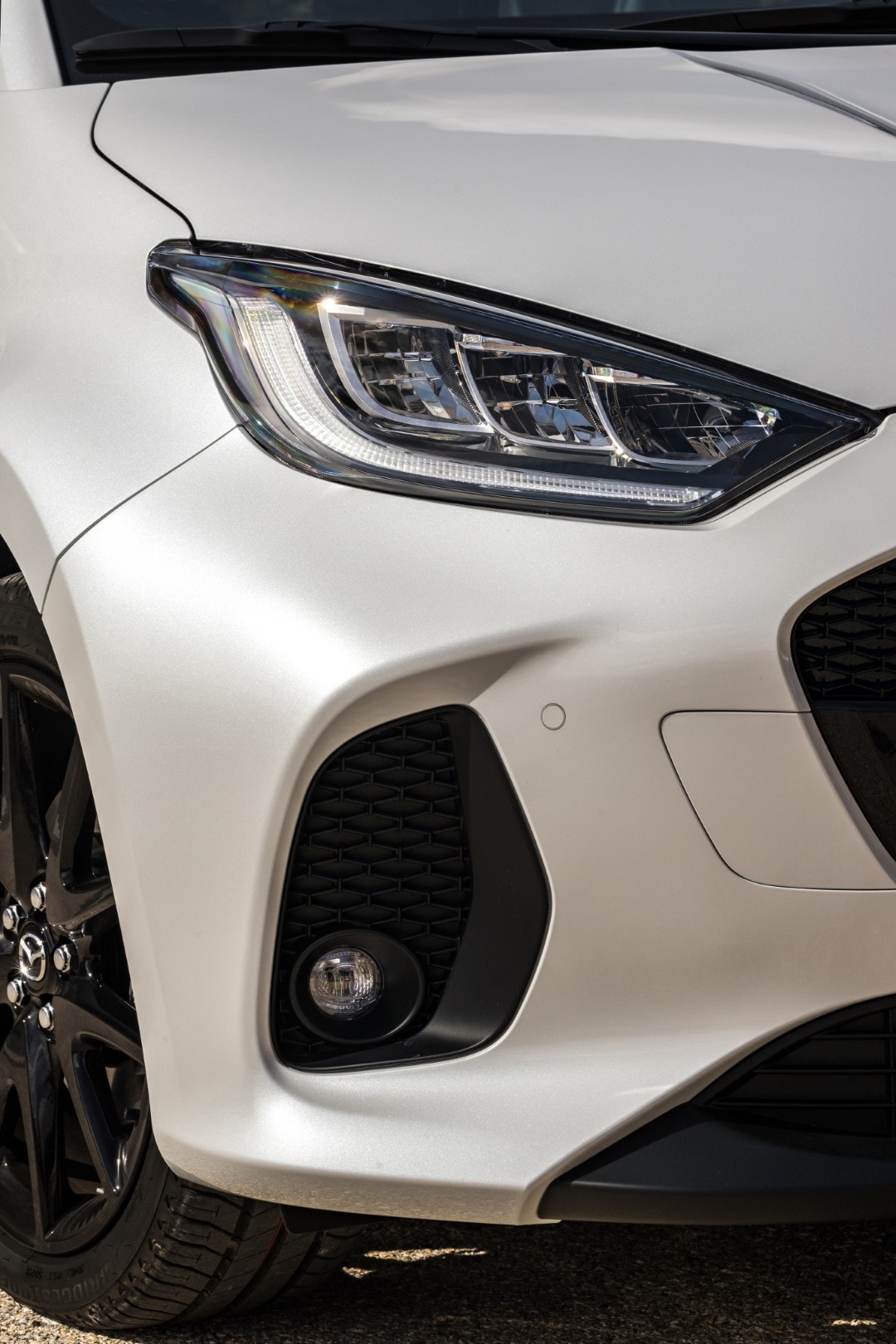 Vista cercana del faro del Mazda 2, destacando su diseño y sofisticada iluminación.