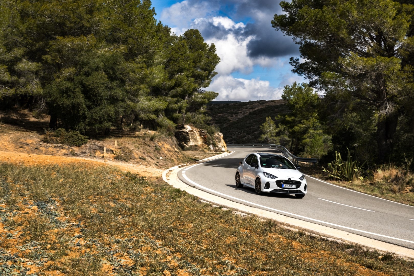 Captura del Mazda 2 híbrido tomando una curva, ideal para visualizar su comportamiento dinámico.