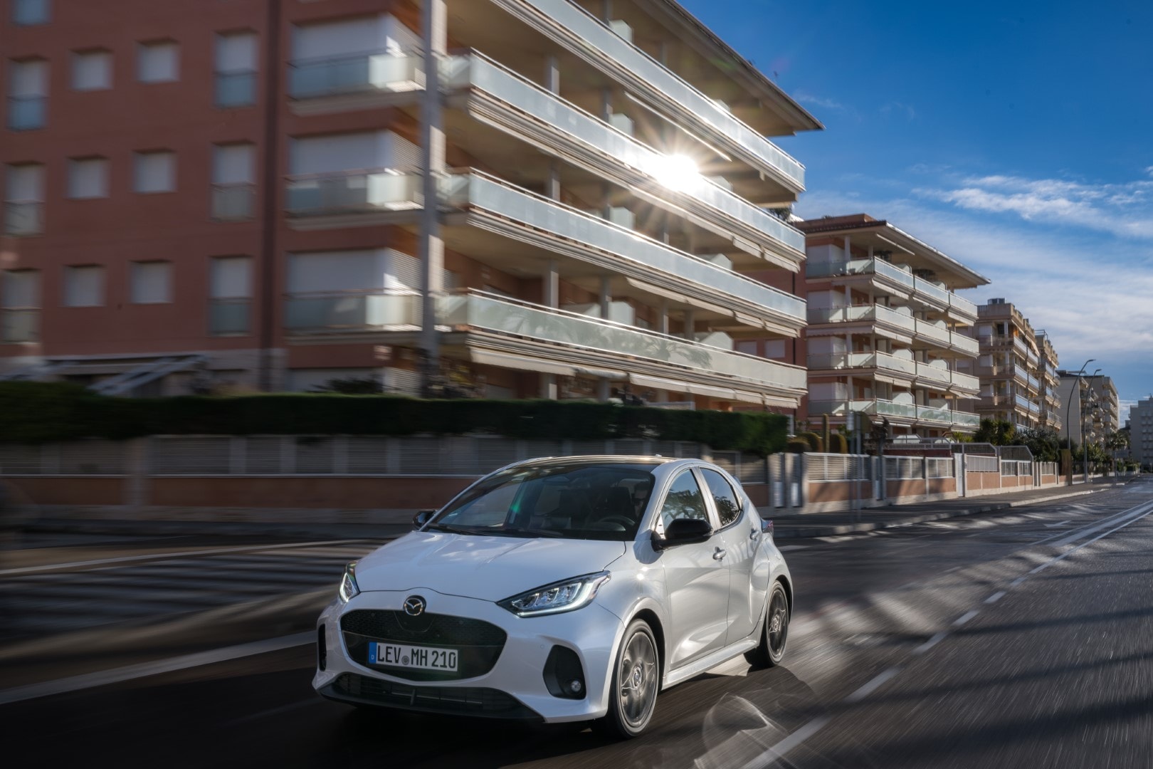 Vista dinámica del Mazda 2 híbrido mostrando su línea delantera y lateral.