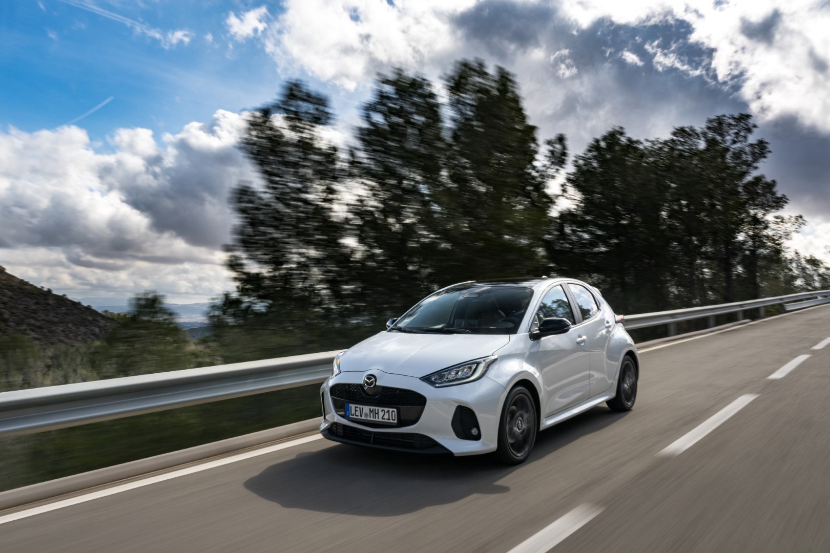 Perspectiva lateral delantera en tránsito, resalta la aerodinámica y estética del vehículo.