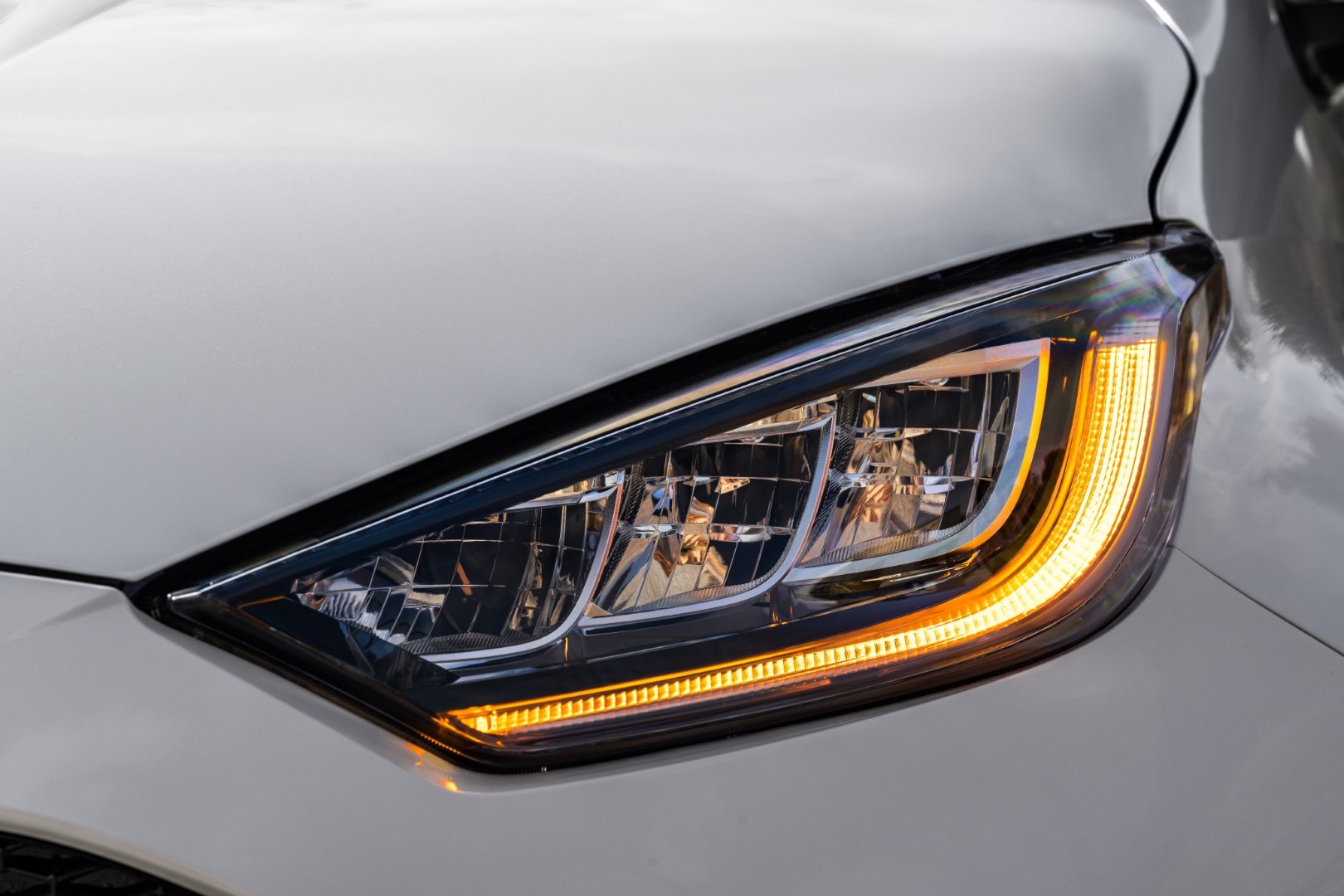 Primer plano de la luz LED del Mazda 2, enfocando en la firma lumínica contemporánea.