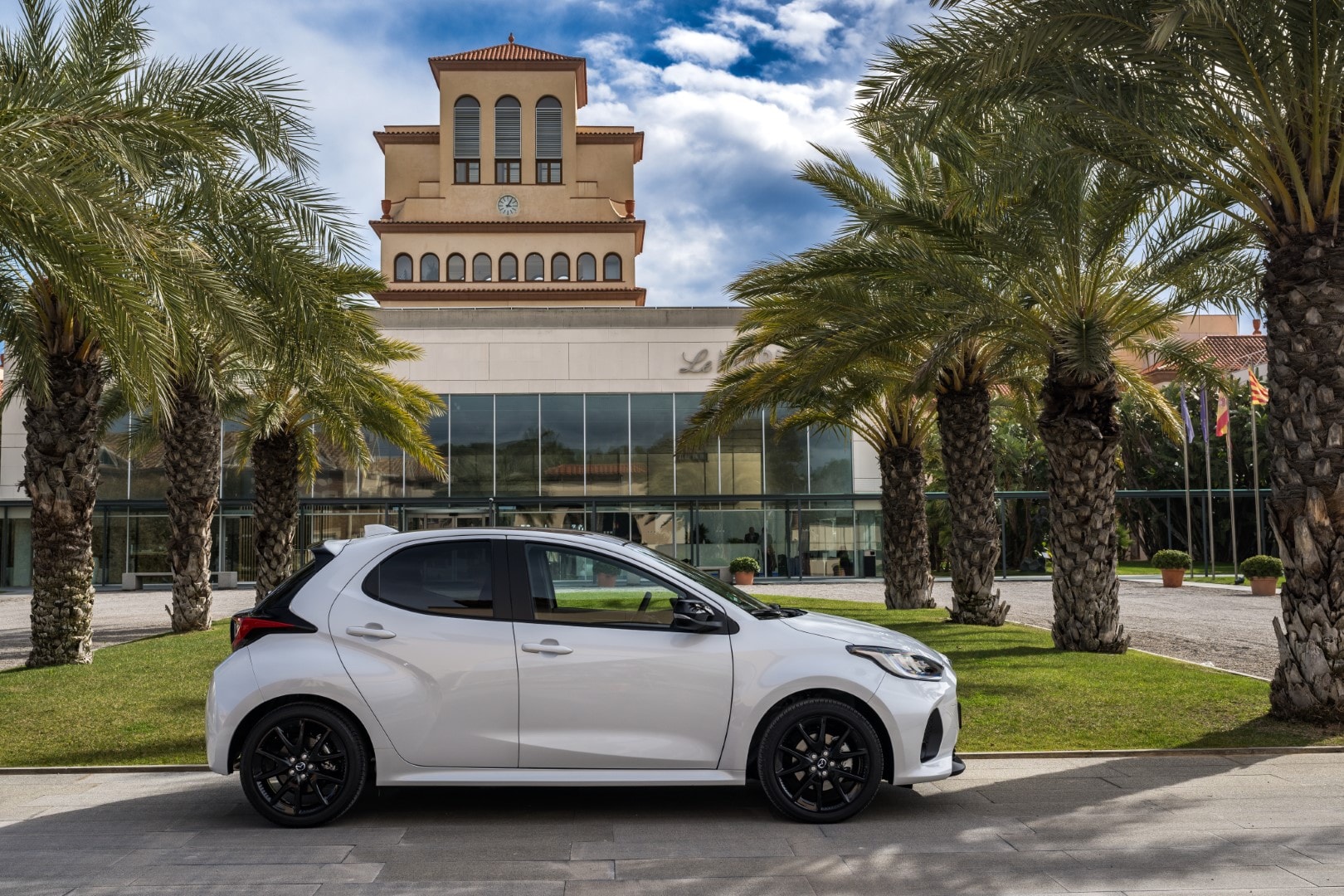 Vista lateral del Mazda 2 hibrido en un contexto urbano.