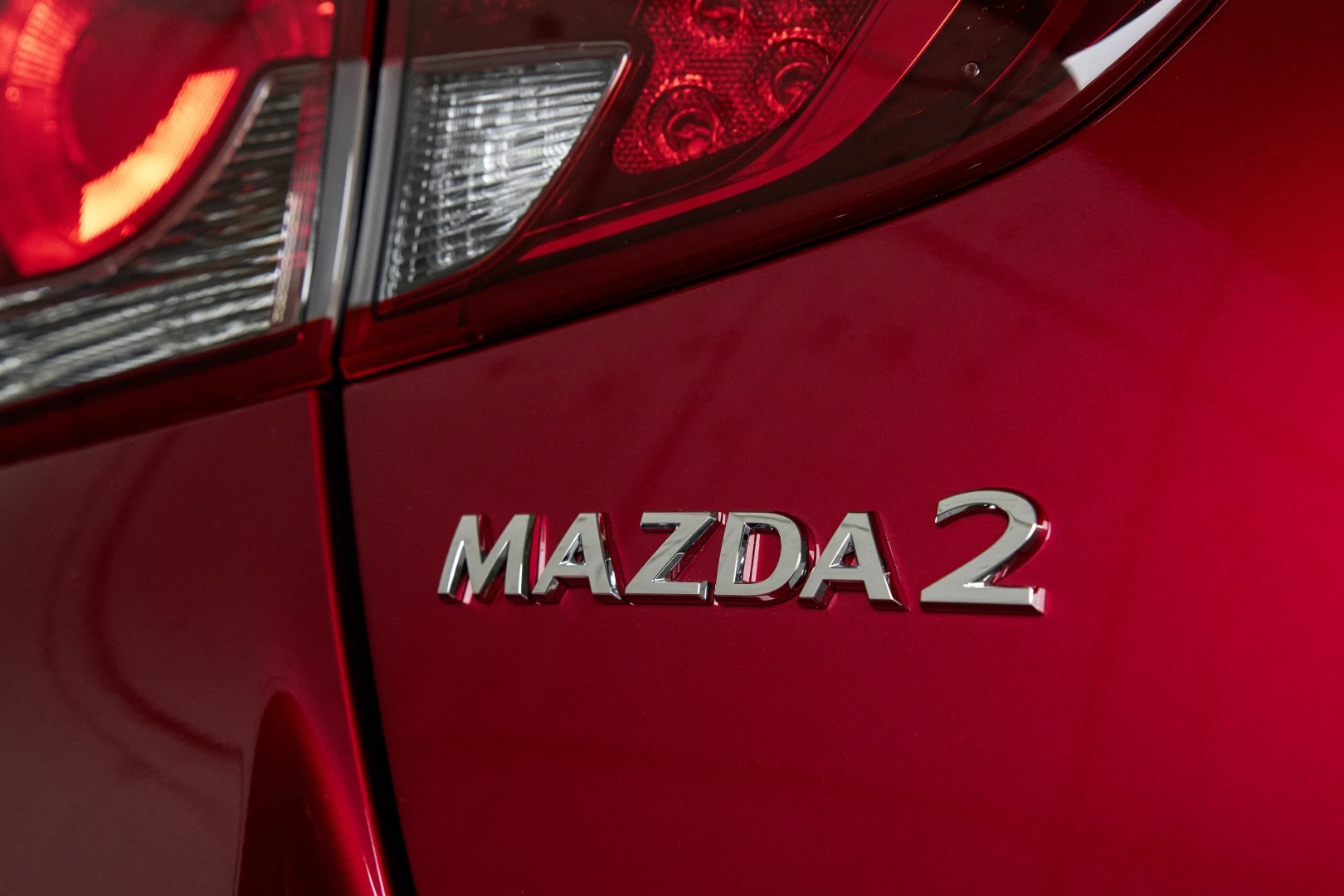 Detalle del emblema Mazda 2 en la parte trasera del vehículo.