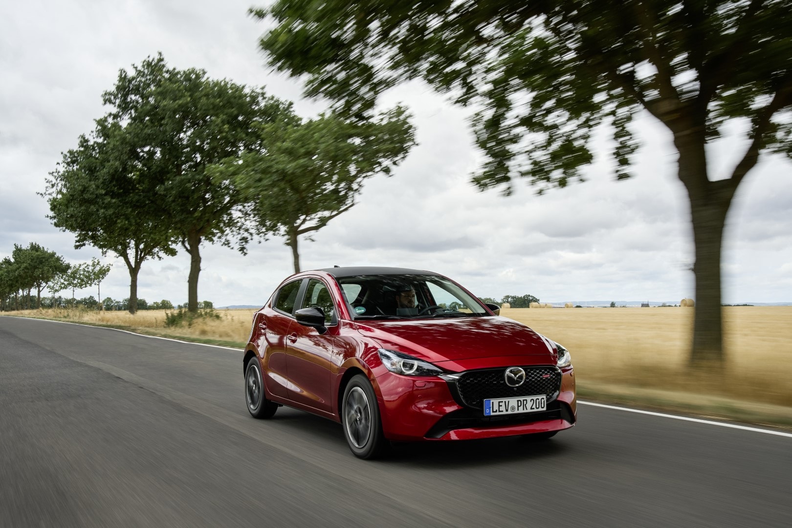 Vista dinámica del Mazda 2 en carretera, destacando su diseño lateral