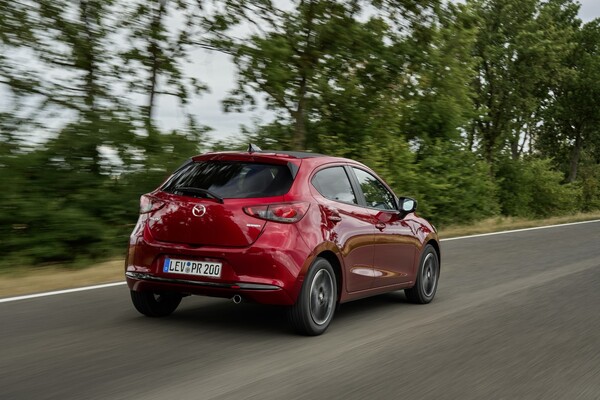 Perspectiva lateral del Mazda 2 circulando por una carretera rural. Perspectiva lateral del Mazda 2 circulando por una carretera rural.