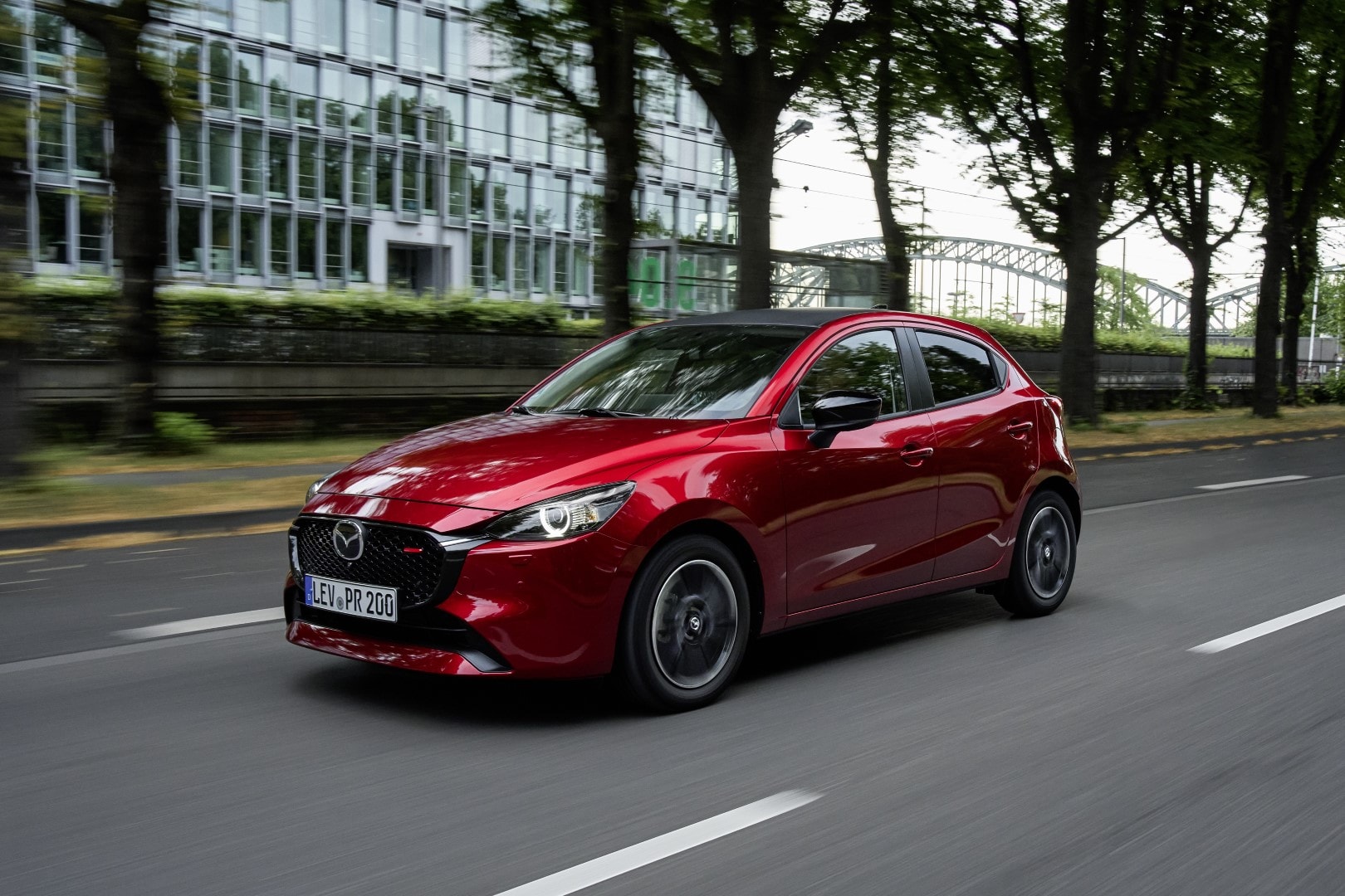 Mazda 2 capturado desde el lateral en un entorno urbano.