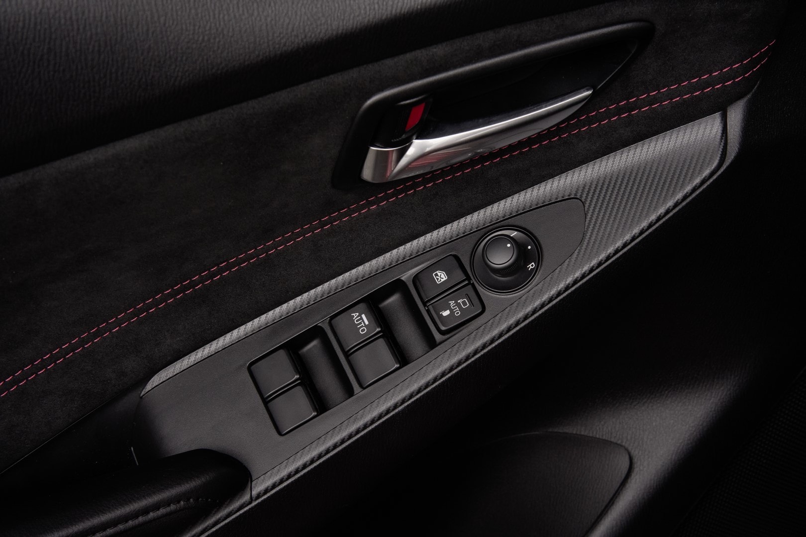 Detalle del panel de la puerta con controles de ventanas eléctricas.