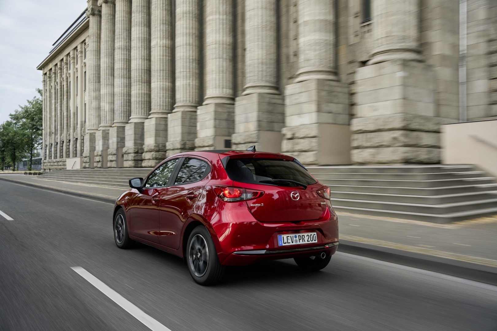 Vista trasera del Mazda 2 en movimiento, realzando su estética dinámica.