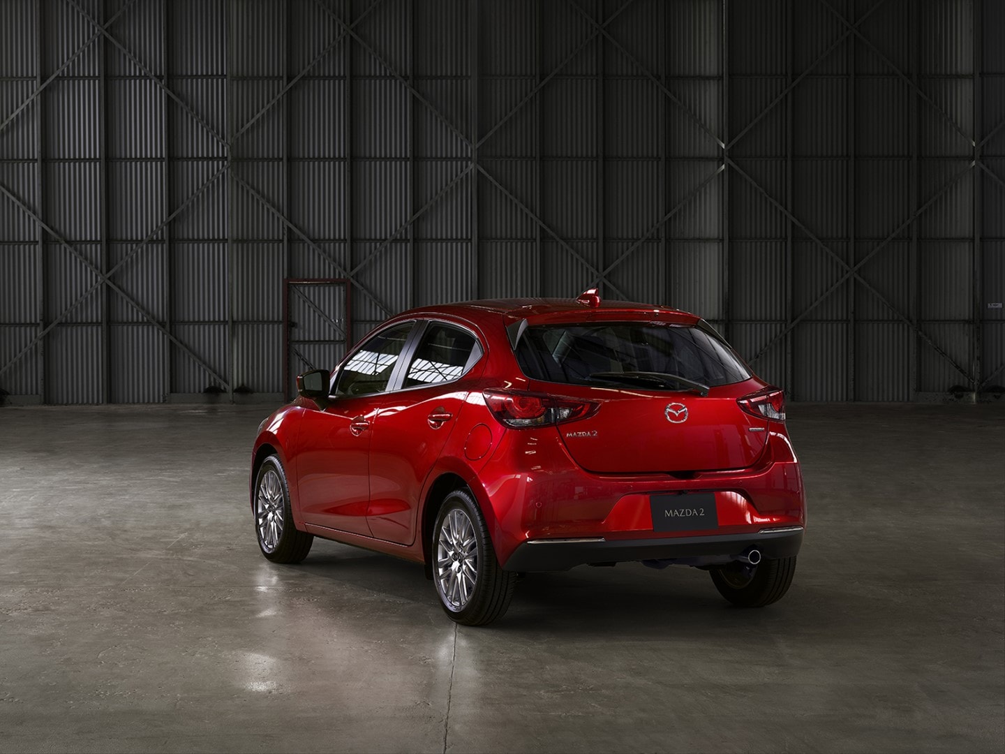 Vista trasera y lateral que muestra el diseño y dimensiones del Mazda 2.