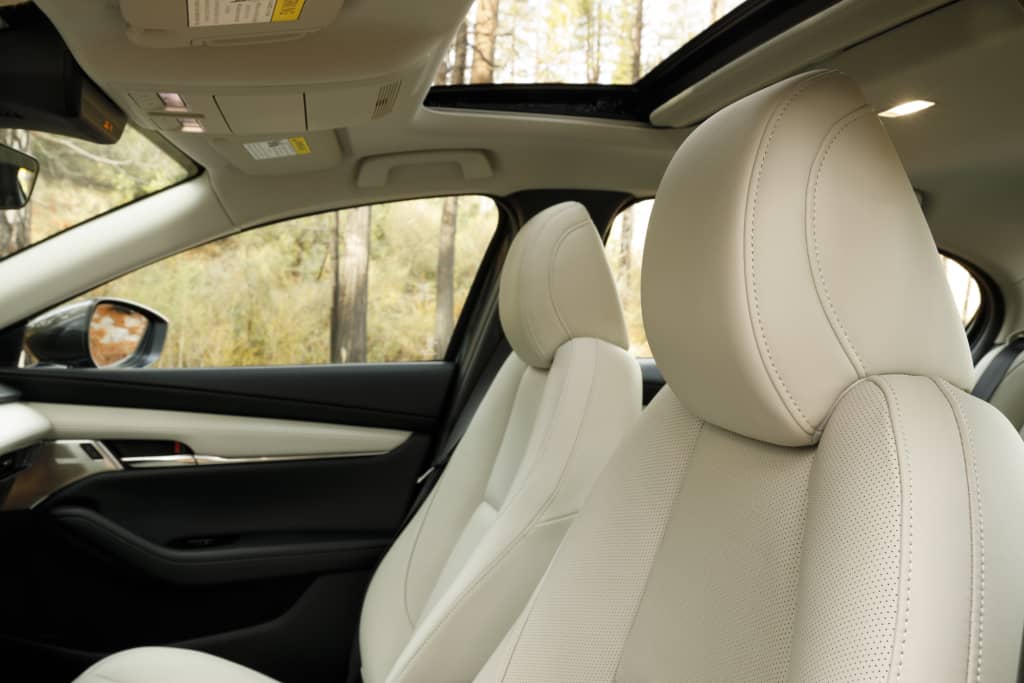 Interiores lujosos con asientos de cuero blanco en el Mazda 3 SportSedán.