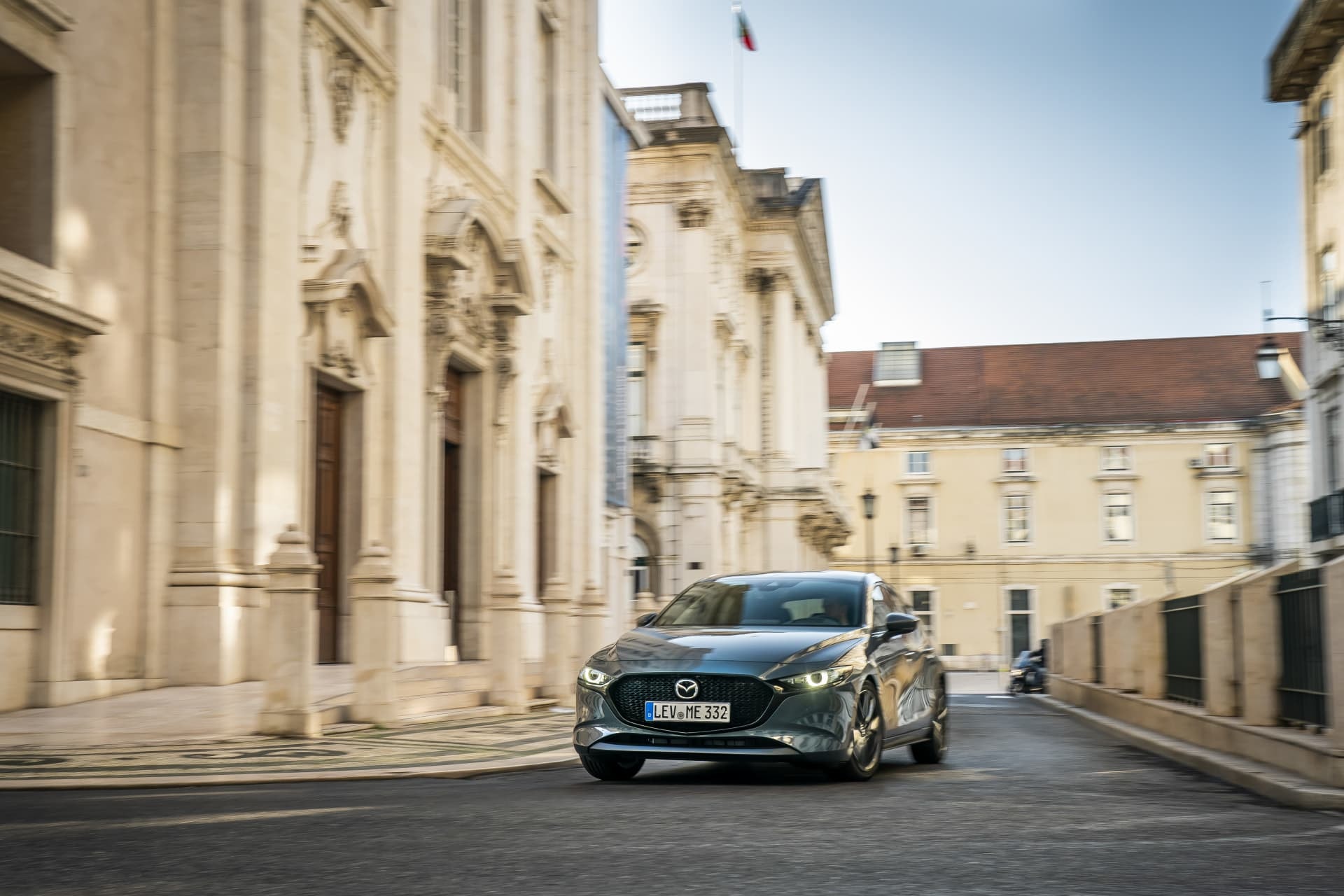 Fotografía que captura la frontal del Mazda 3 en un contexto urbano.
