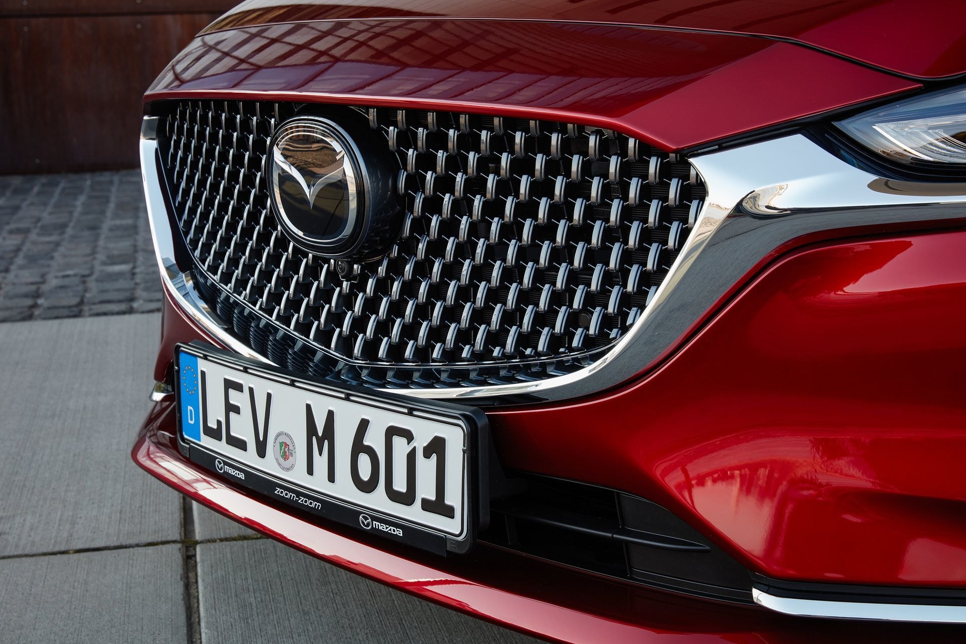 Imagen que muestra la parrilla delantera del Mazda 6, ícono de la marca y detalle de distinción del modelo.