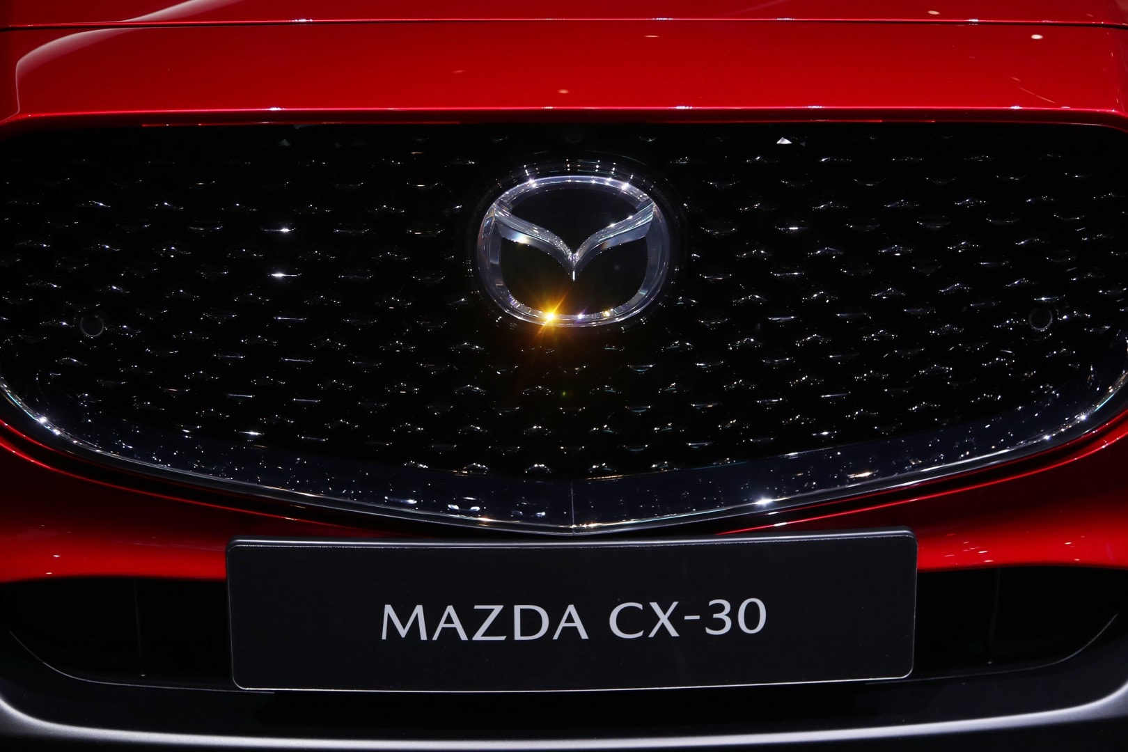 Primer plano del emblema de Mazda en la parrilla del CX-30.