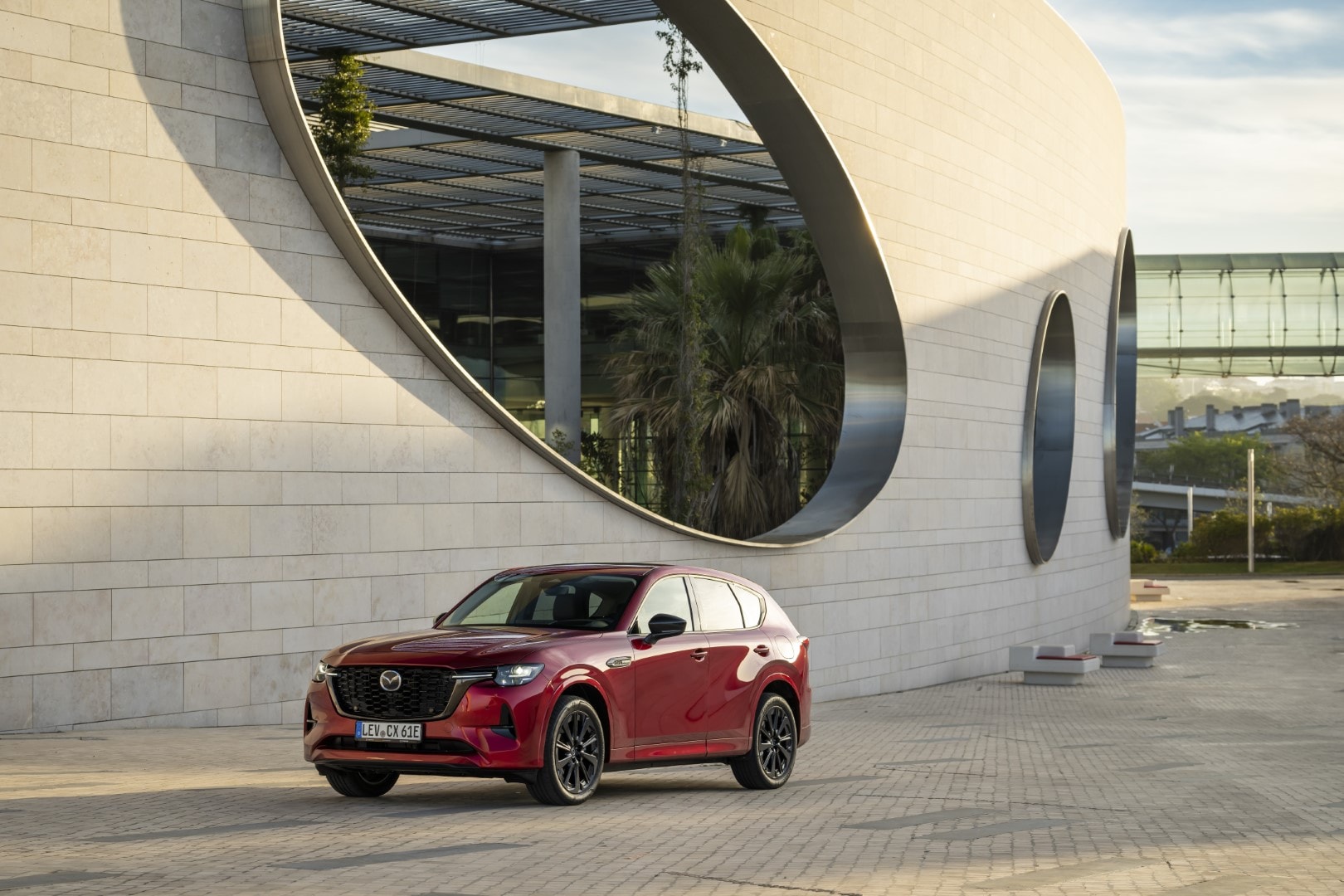 El Mazda CX-60 posando con estilo ante una arquitectura contemporánea.