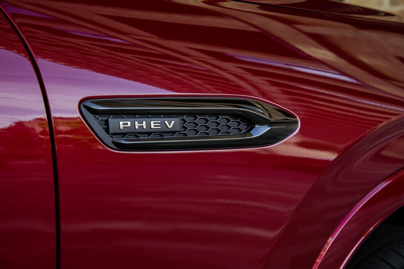 Primer plano del emblema PHEV que denota la variante híbrida enchufable.