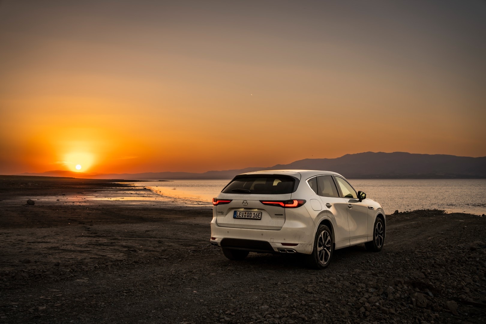 Vista trasera y lateral del Mazda CX-60 al atardecer.