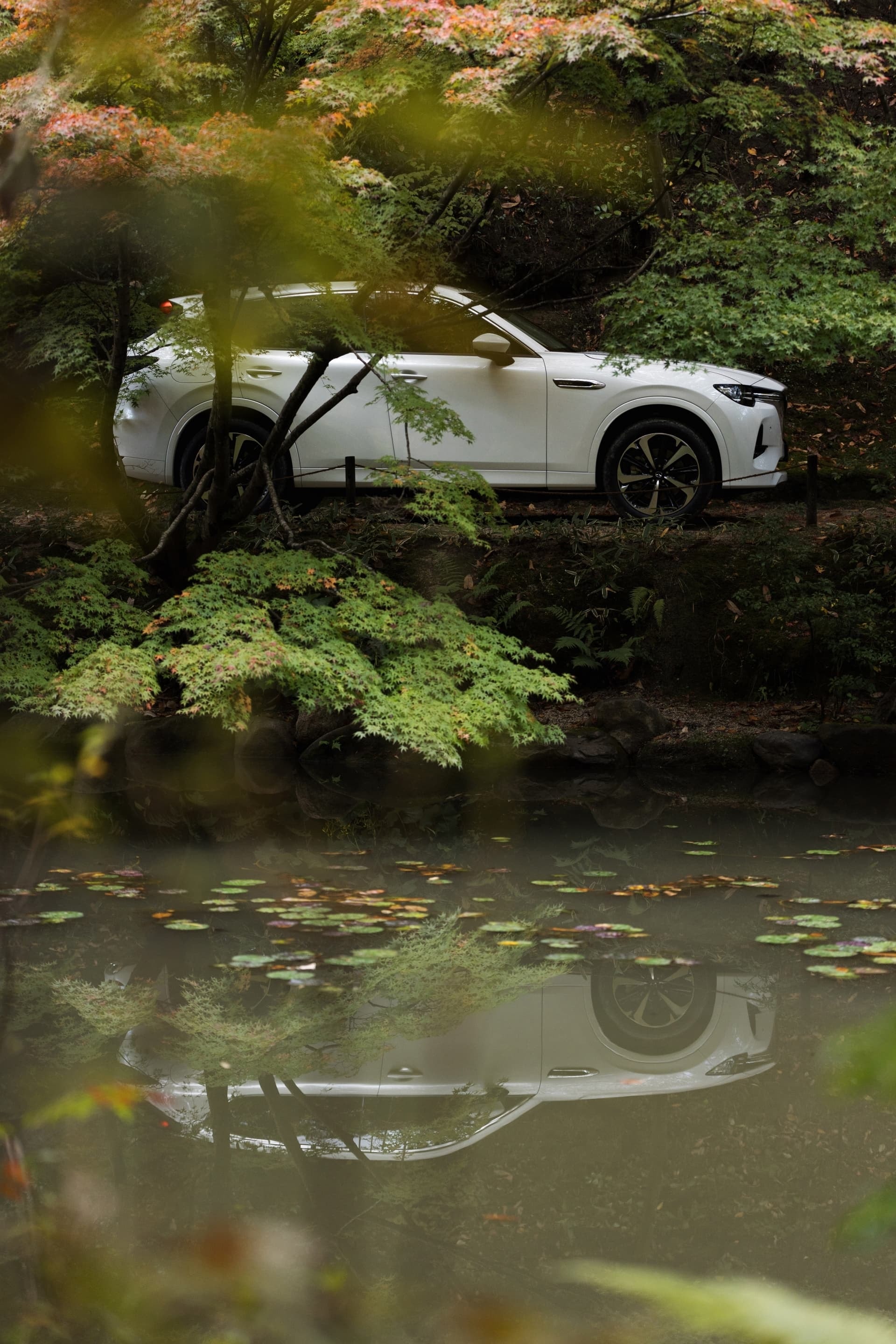 Vista lateral del Mazda CX-60 con las puertas abiertas en entorno natural.