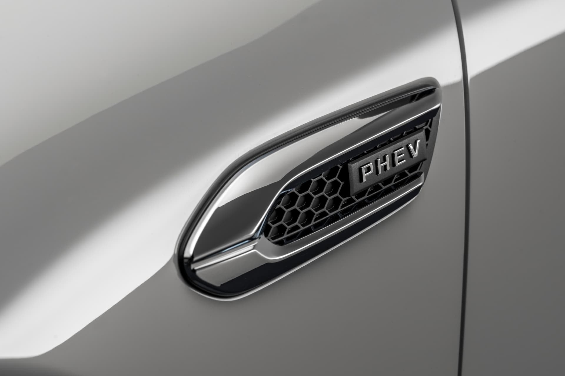 Visión más amplia del emblema PHEV, destacando su ubicación en el vehículo.