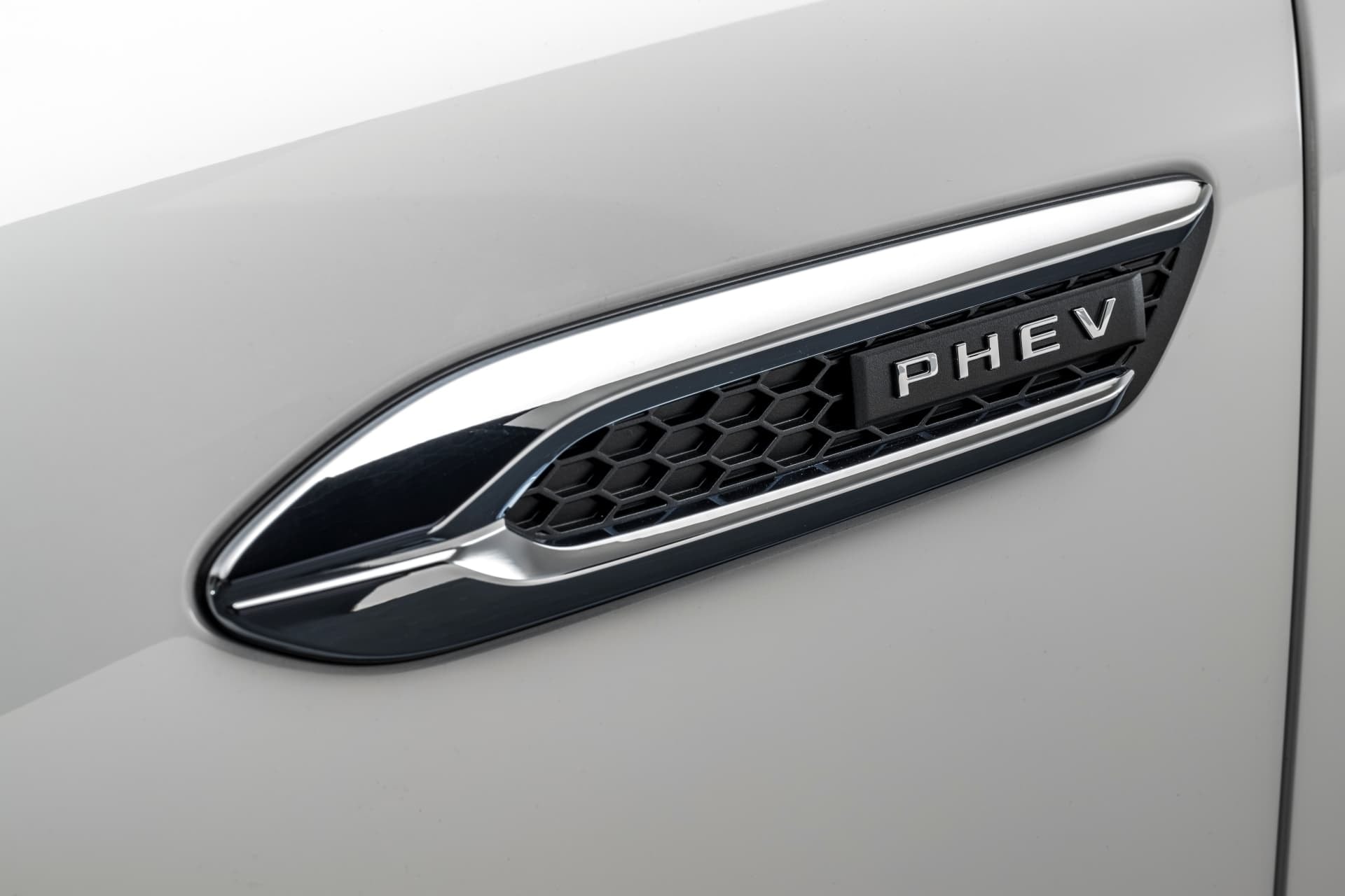 Primer plano del emblema PHEV que identifica el modelo híbrido enchufable.