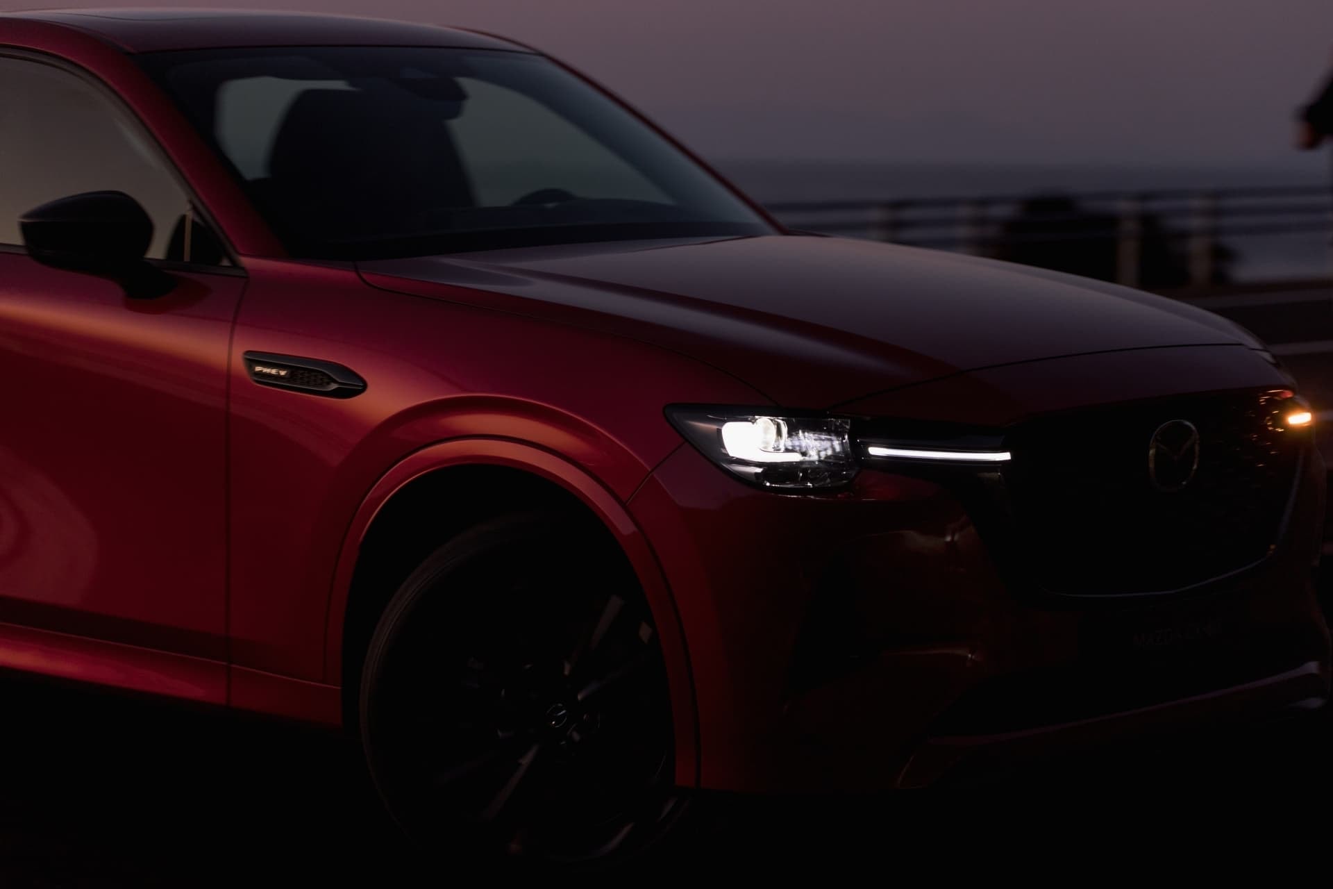 Detalle de las luces delanteras LED del Mazda CX-60 al atardecer.