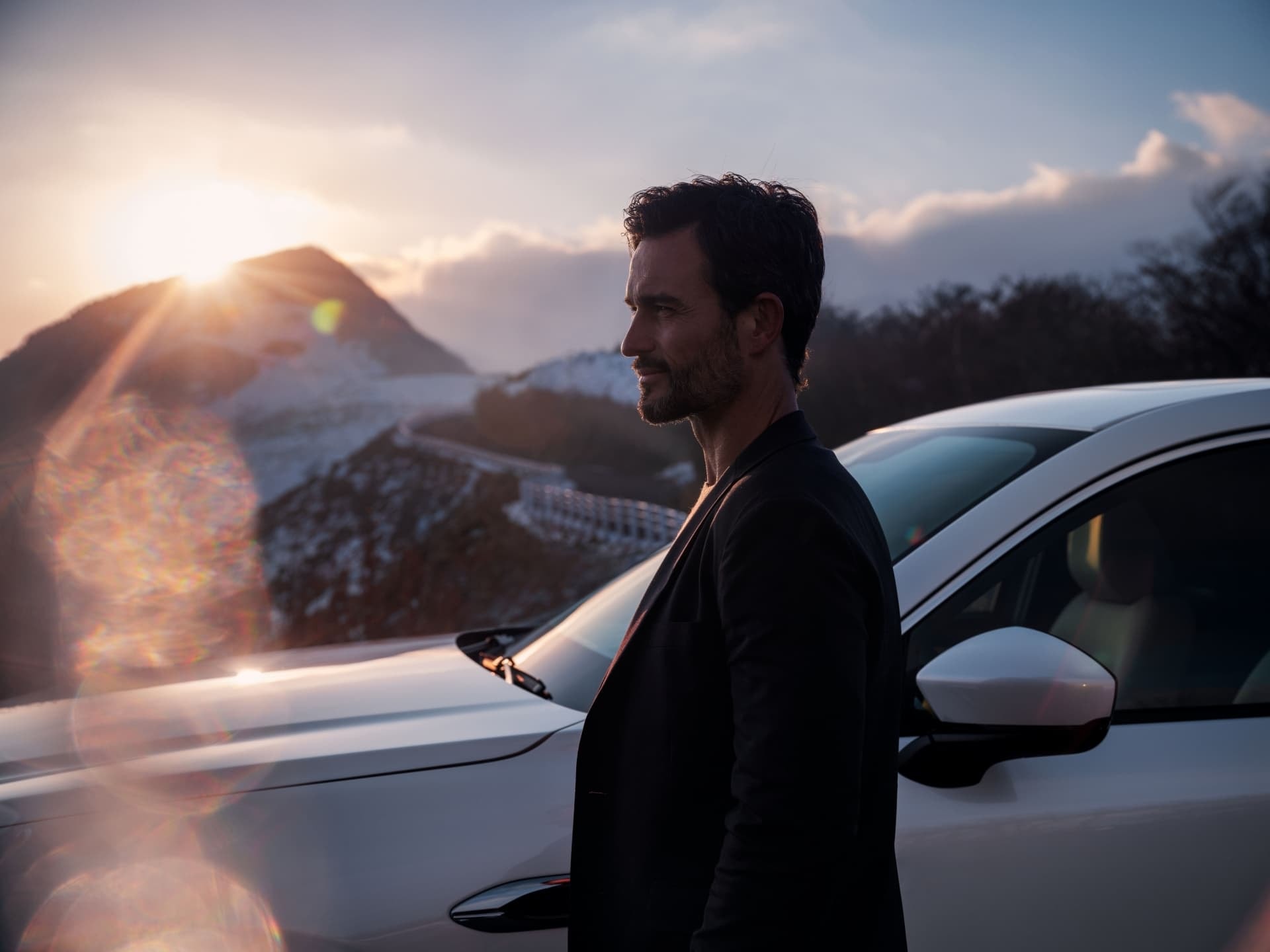 Hombre junto al Mazda CX-60 con puesta de sol de fondo.