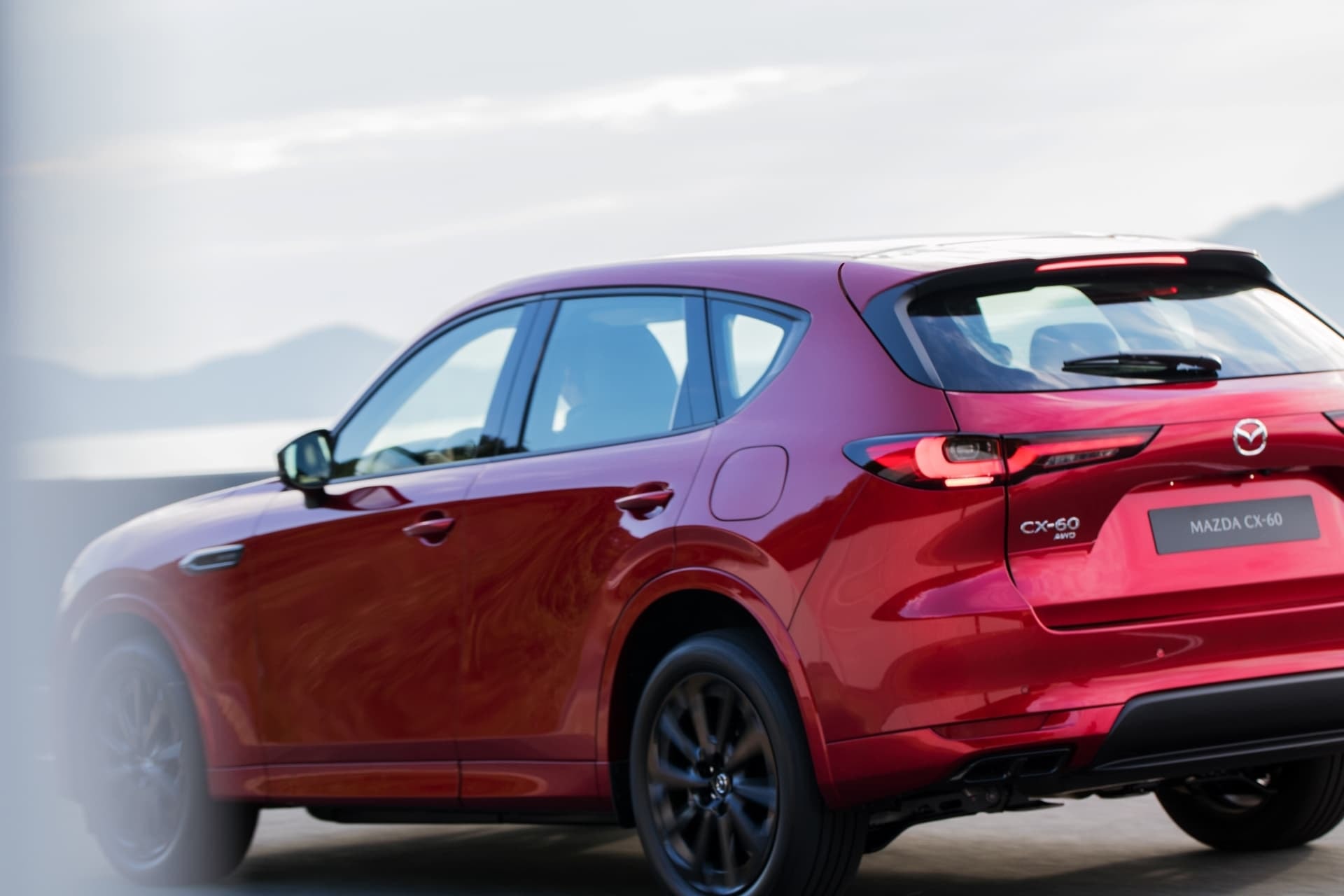 Imagen que muestra la trasera y perfil del Mazda CX-60 en color rojo.