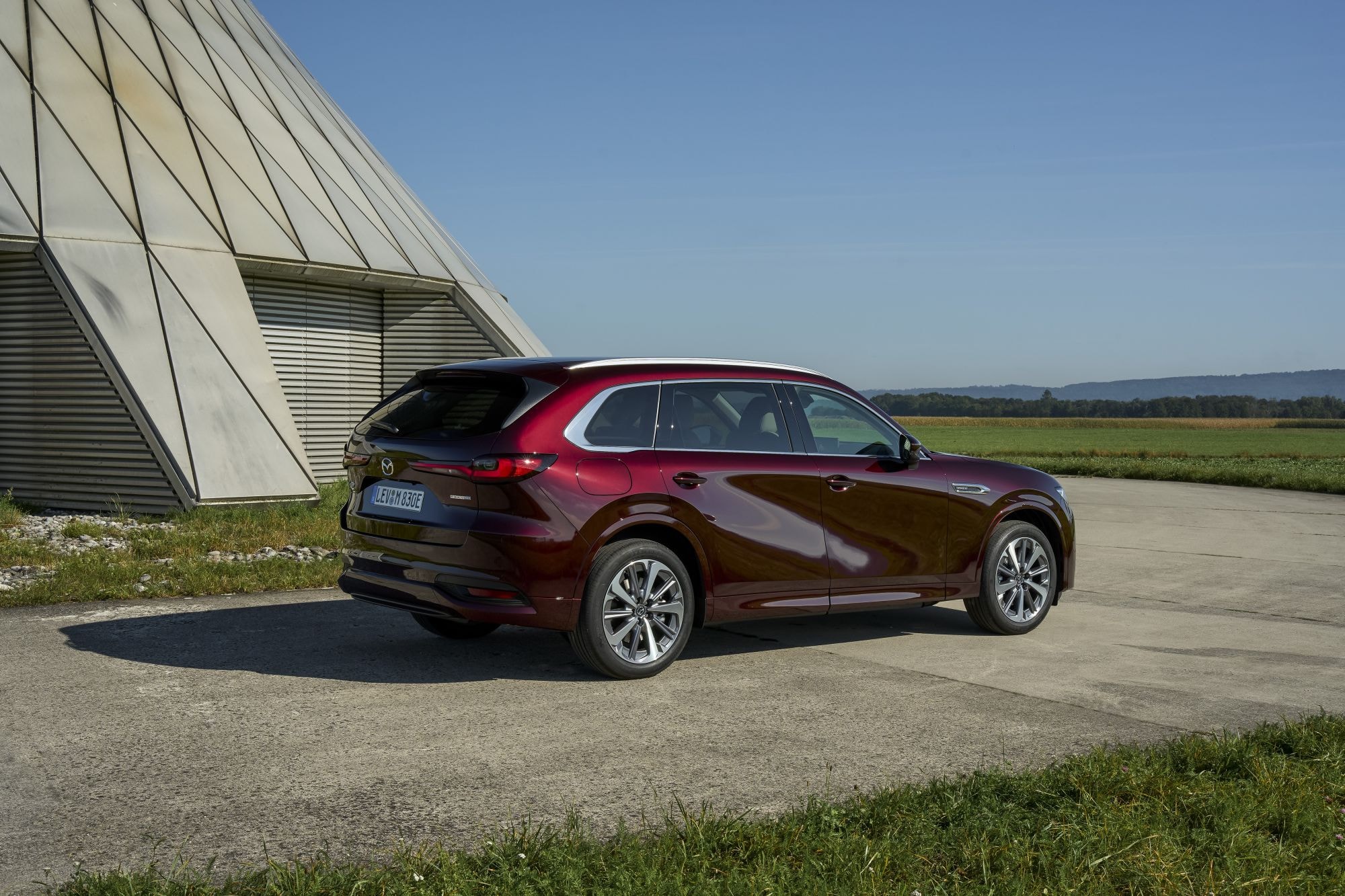 Mazda CX-80 en un entorno arquitectónico moderno, destaca su diseño.