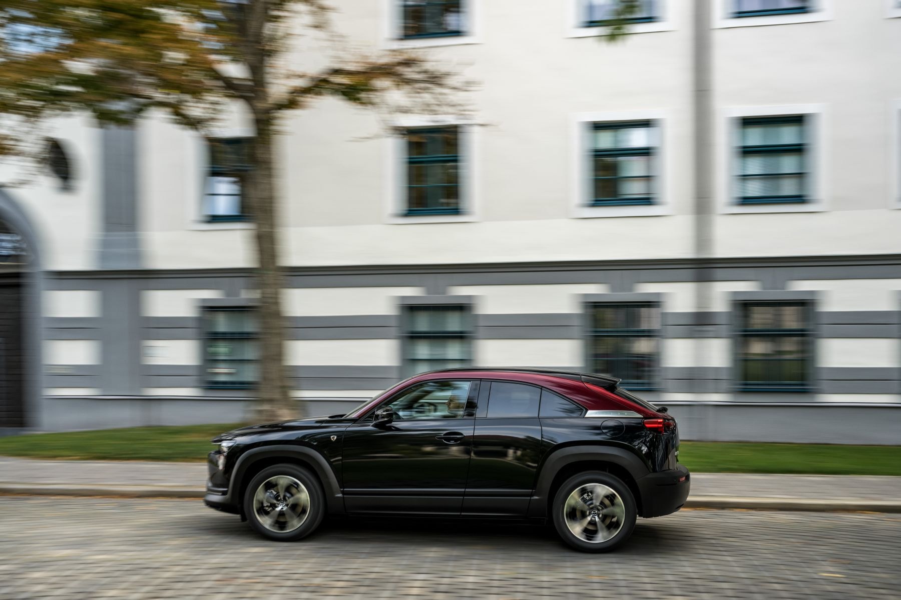 Mazda MX-30 Híbrido atravesando la ciudad, mostrando elegancia.