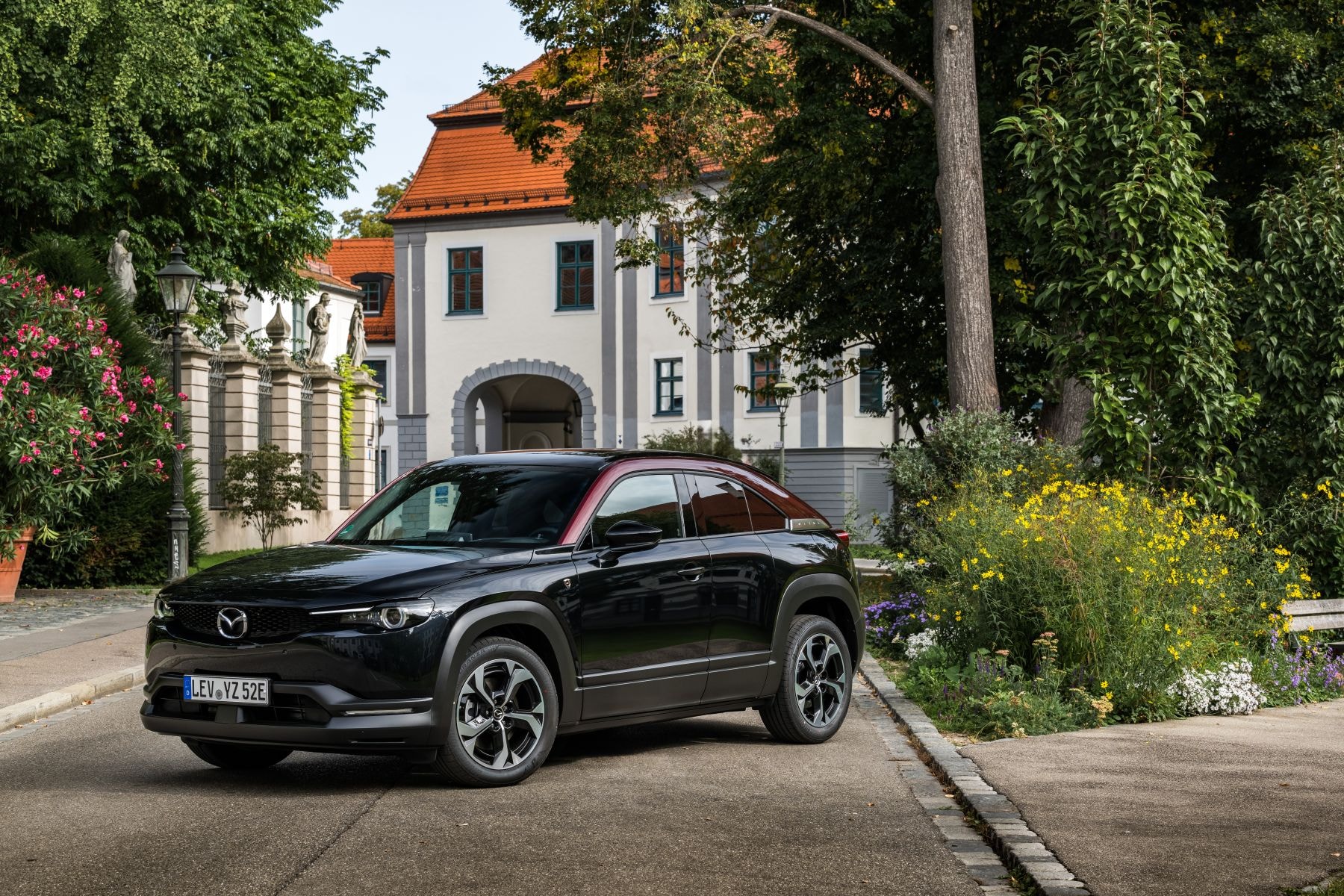 Perfil lateral del MX-30, en un entorno urbano que resalta su versatilidad.