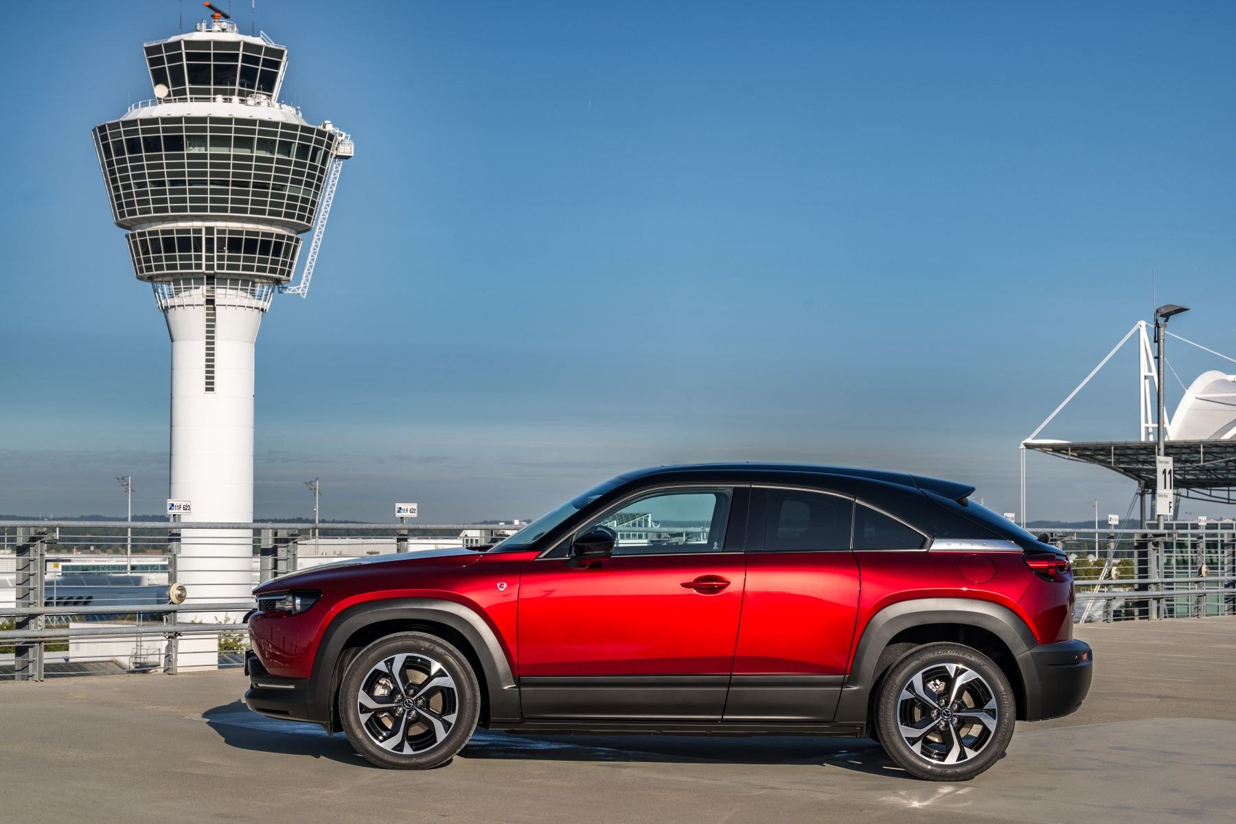 Vista lateral del Mazda MX-30 eléctrico con un fondo moderno.
