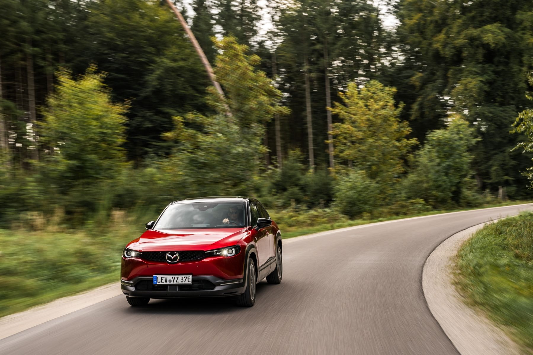 El Mazda MX-30 toma curvas con elegancia, mostrando su diseño aerodinámico.