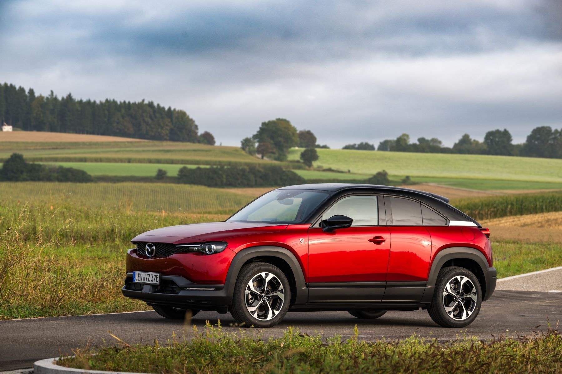 Perspectiva lateral y frontal del Mazda MX-30, resaltando su diseño moderno.