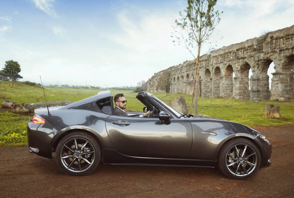 Perfil lateral del Mazda MX-5 RF con el techo retráctil abierto.