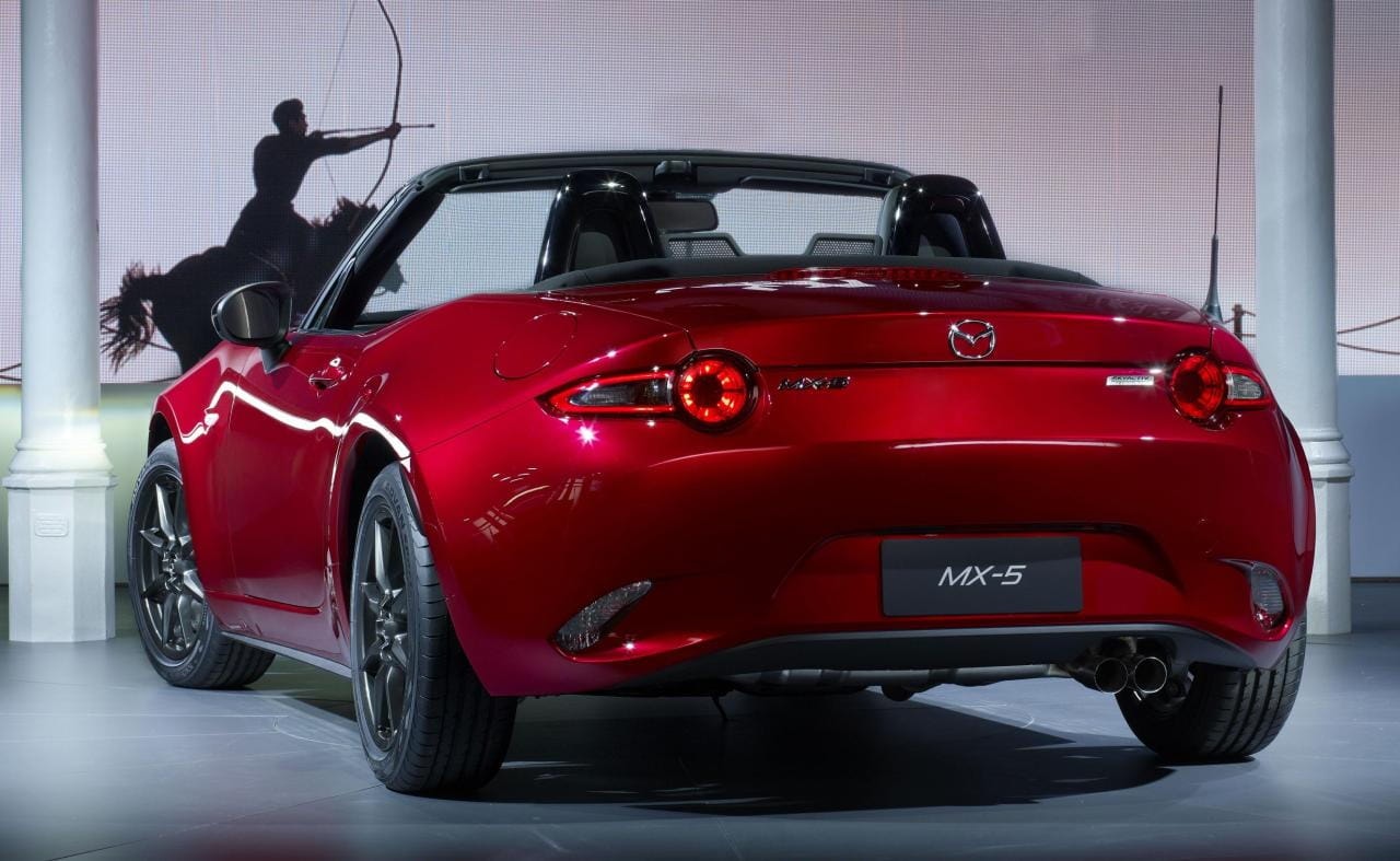 Vista trasera del Mazda MX-5 mostrada en una exhibición, resalta su atractivo diseño.