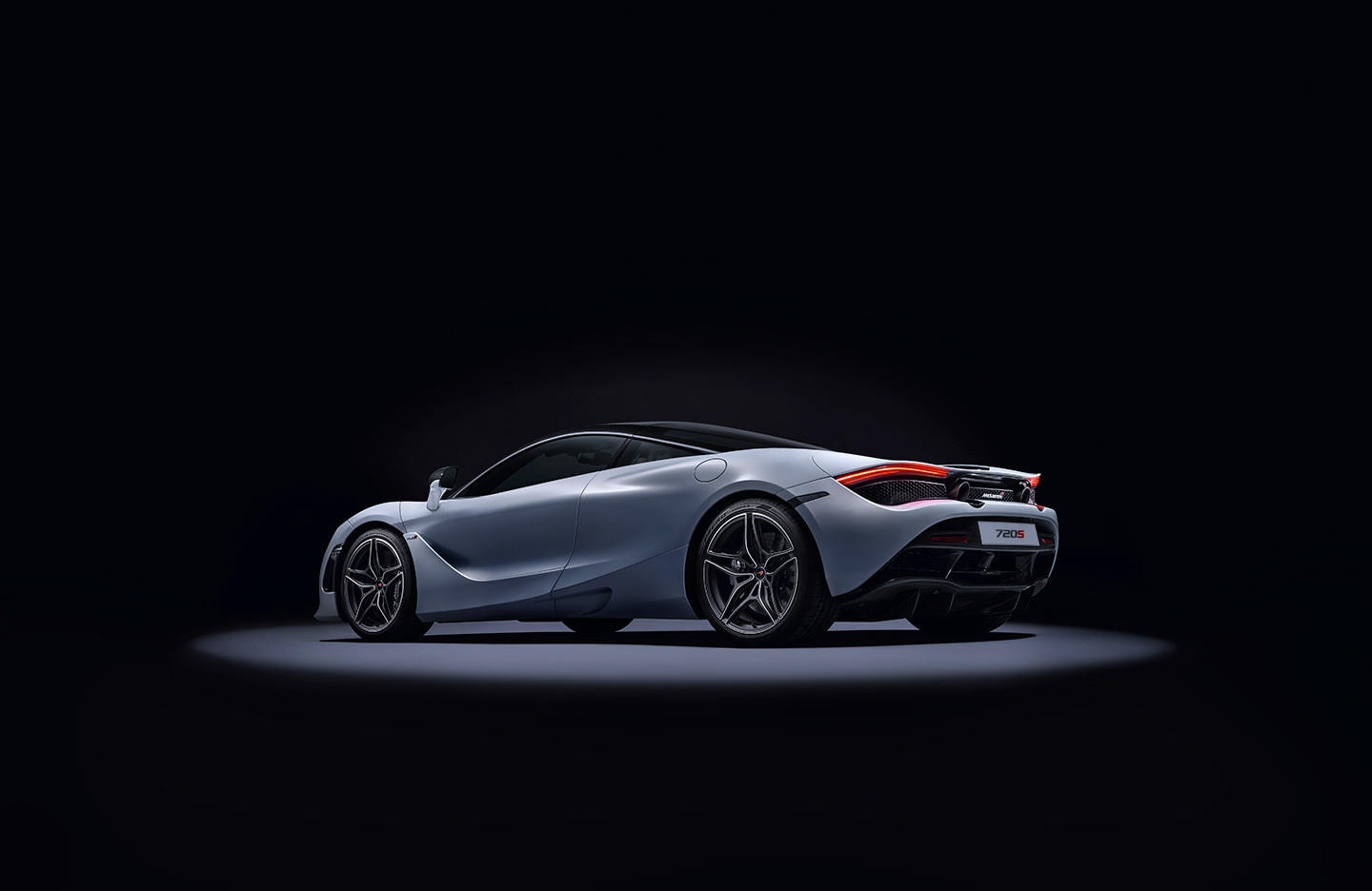 Vista posterior del McLaren 720S iluminado de forma dramática.